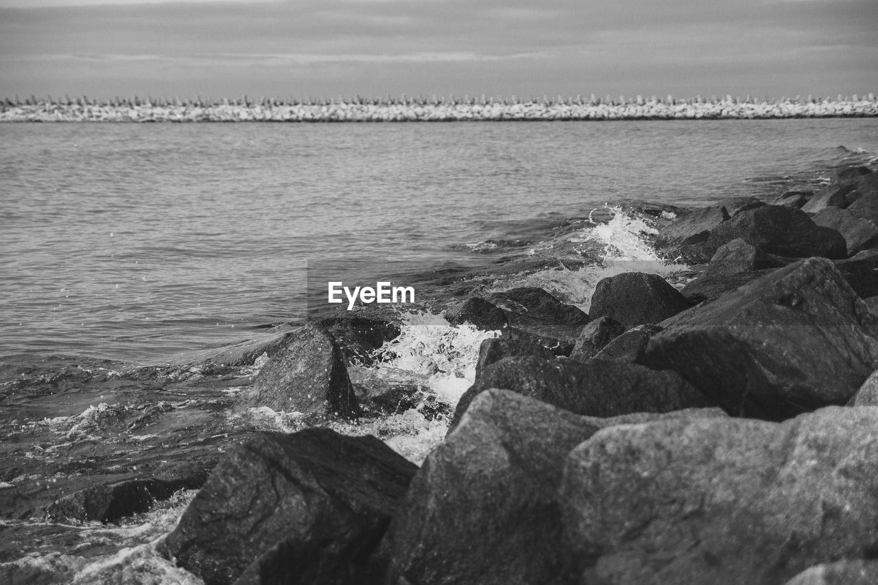 ROCKS IN SEA AGAINST SKY