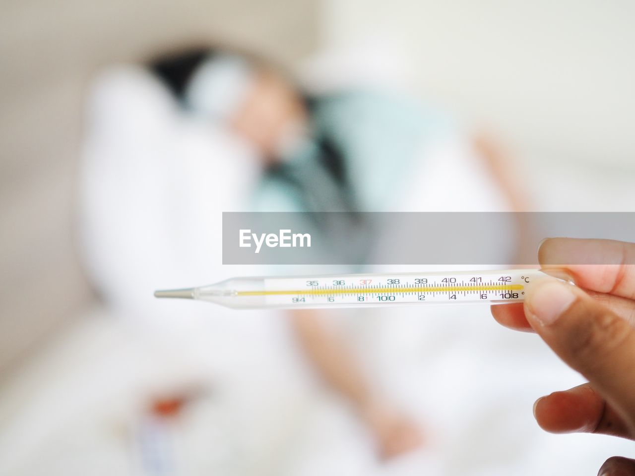 Cropped hand of doctor holding thermometer