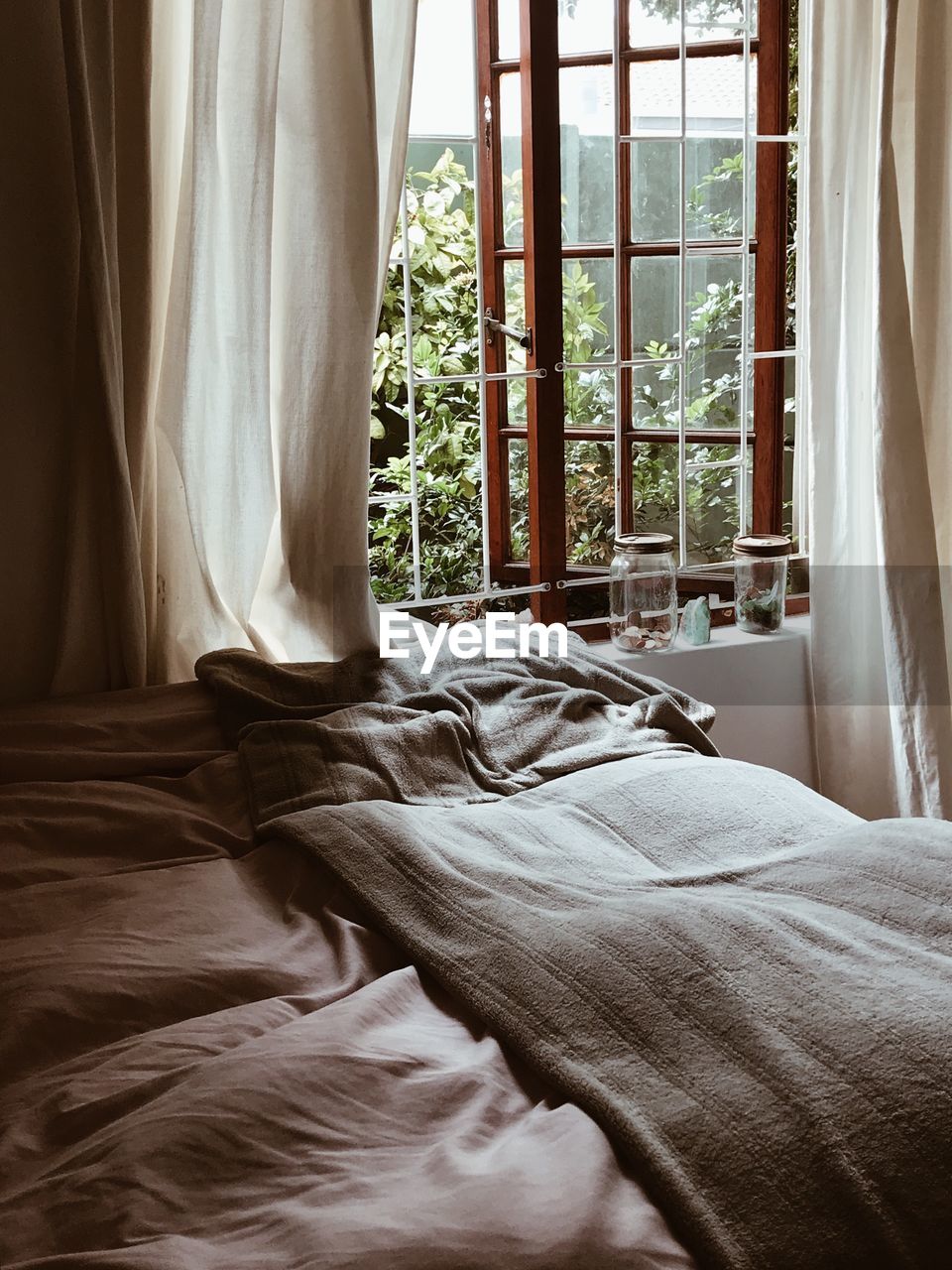 Close-up of bed by window at home