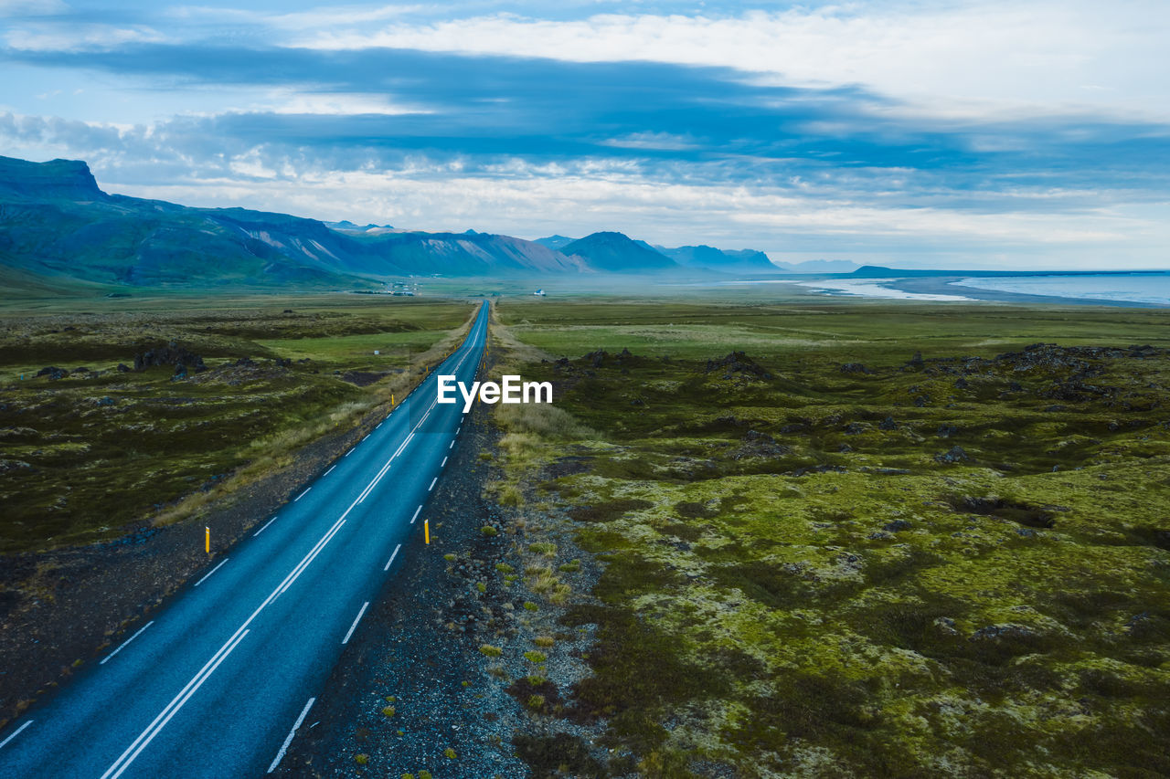 EMPTY ROAD LEADING TOWARDS MOUNTAINS