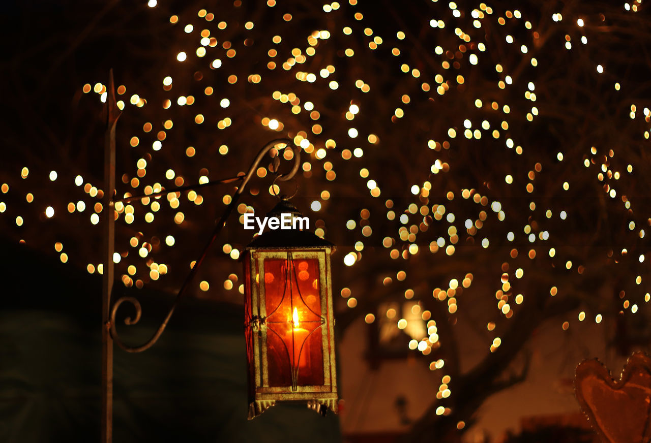 Low angle view of illuminated light hanging at night