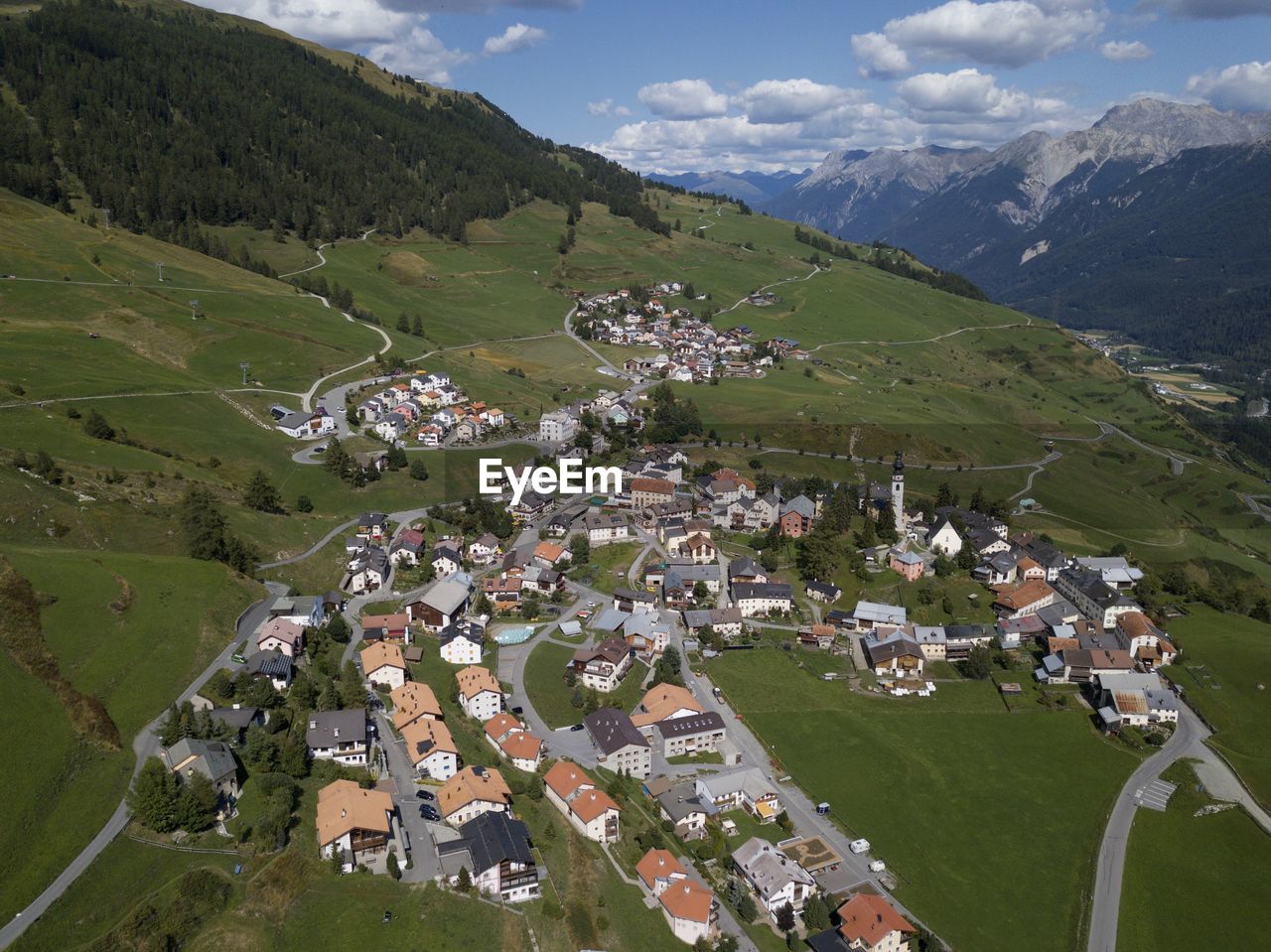 High angle view of houses on field by mountain