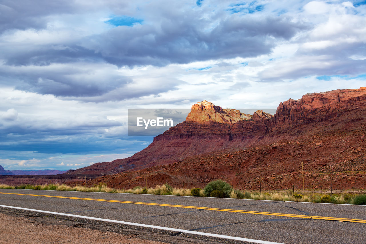 Country road passing through grand canyon national park against cloudy sky