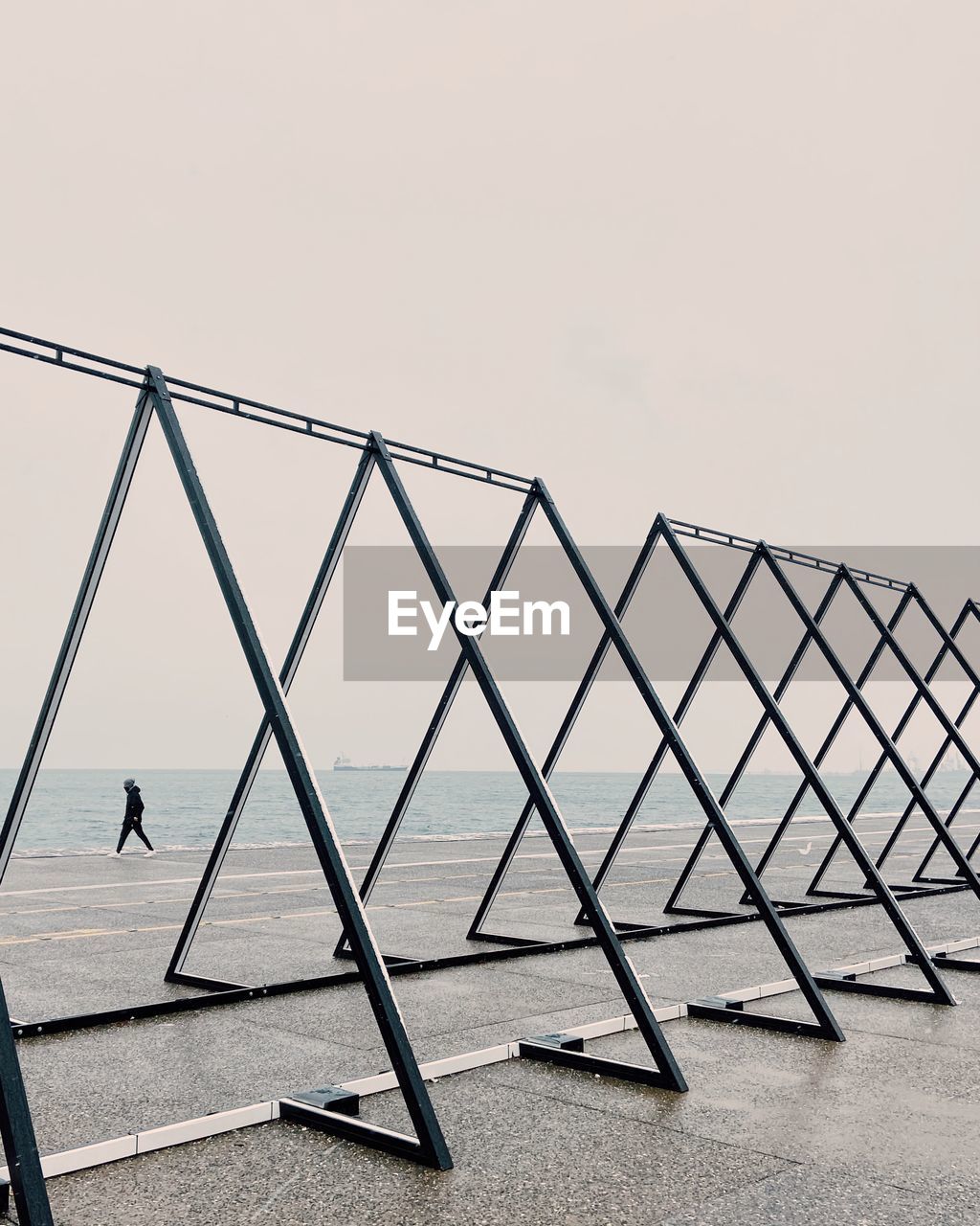 Man by sea against sky triangle shape