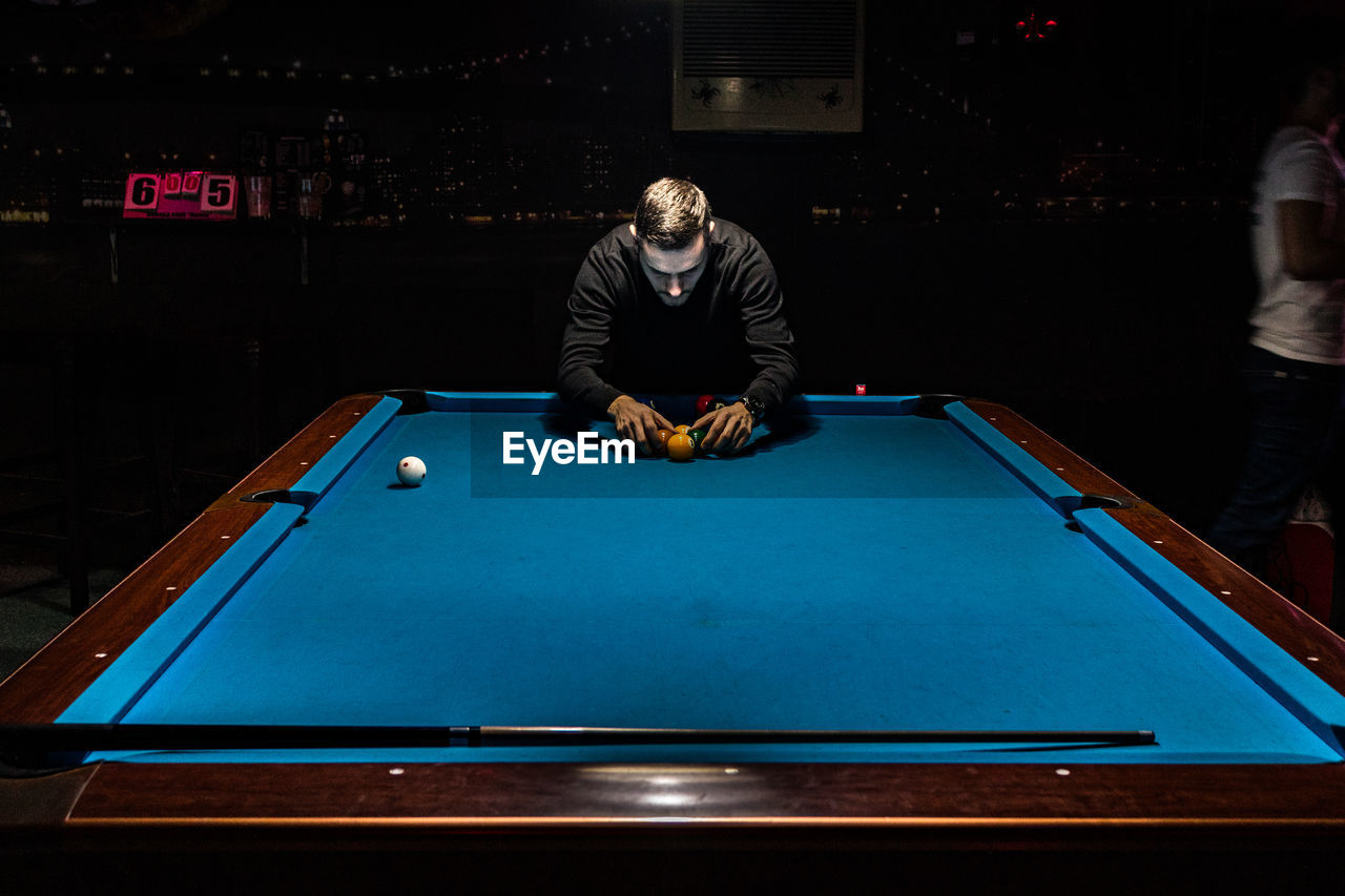 MAN PLAYING WITH BALL ON TABLE AT HOME