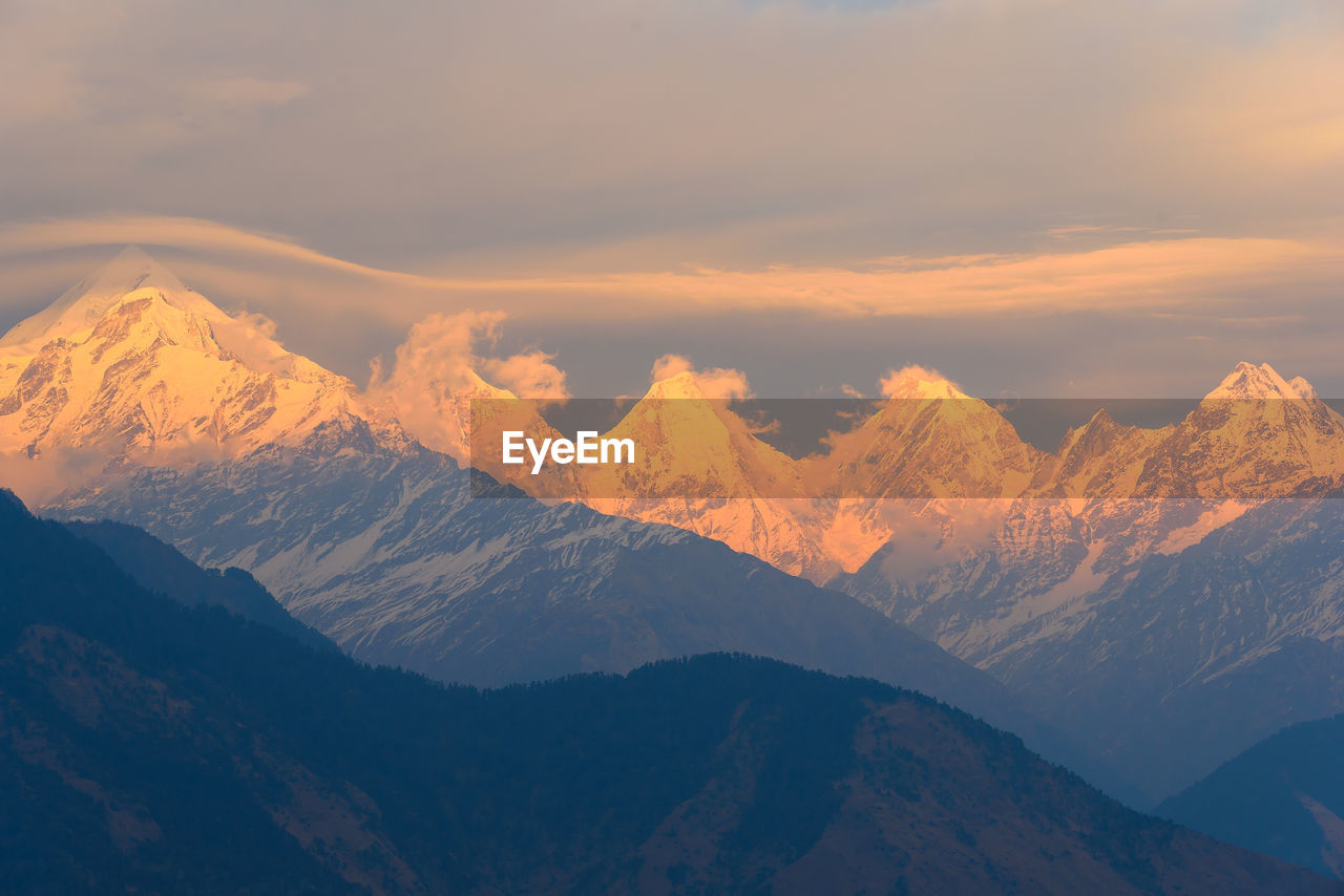 Scenic view of snowcapped mountains against sky during sunset