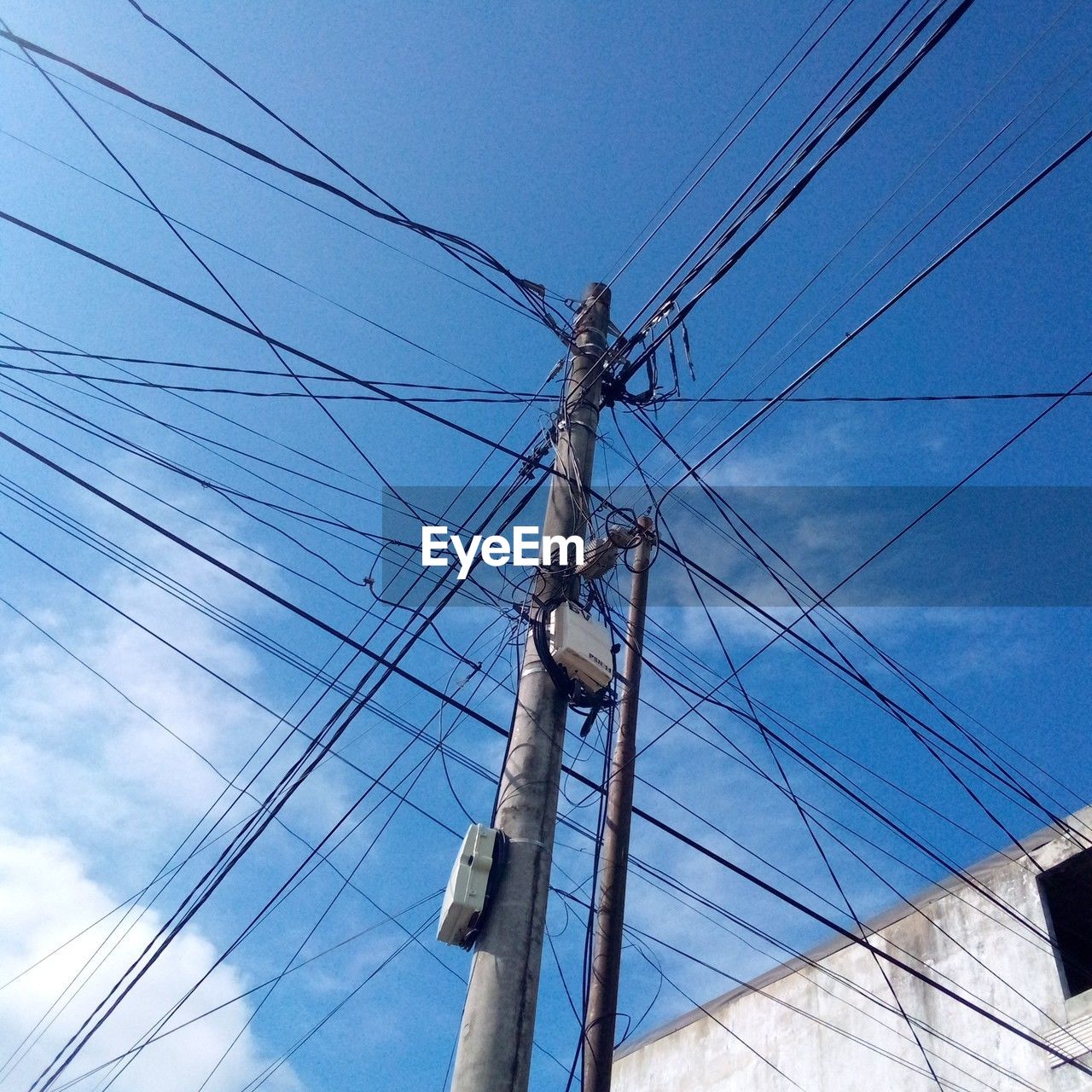 cable, electricity, power supply, low angle view, technology, power line, sky, power generation, electricity pylon, overhead power line, blue, no people, complexity, nature, mast, day, pole, electrical supply, telephone pole, cloud, telephone line, outdoors, transmission tower, architecture, tower, line
