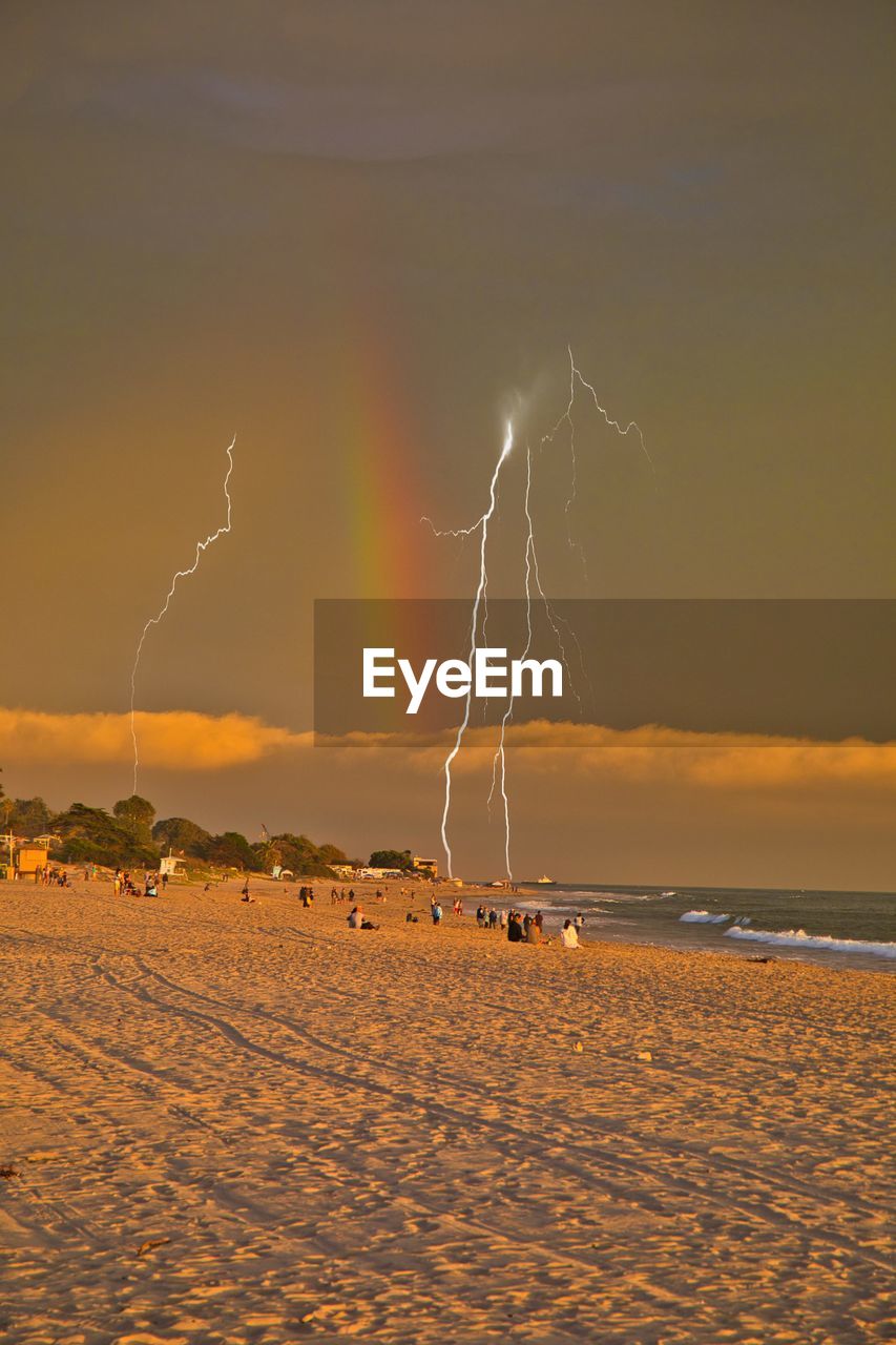 scenic view of beach against sky at sunset