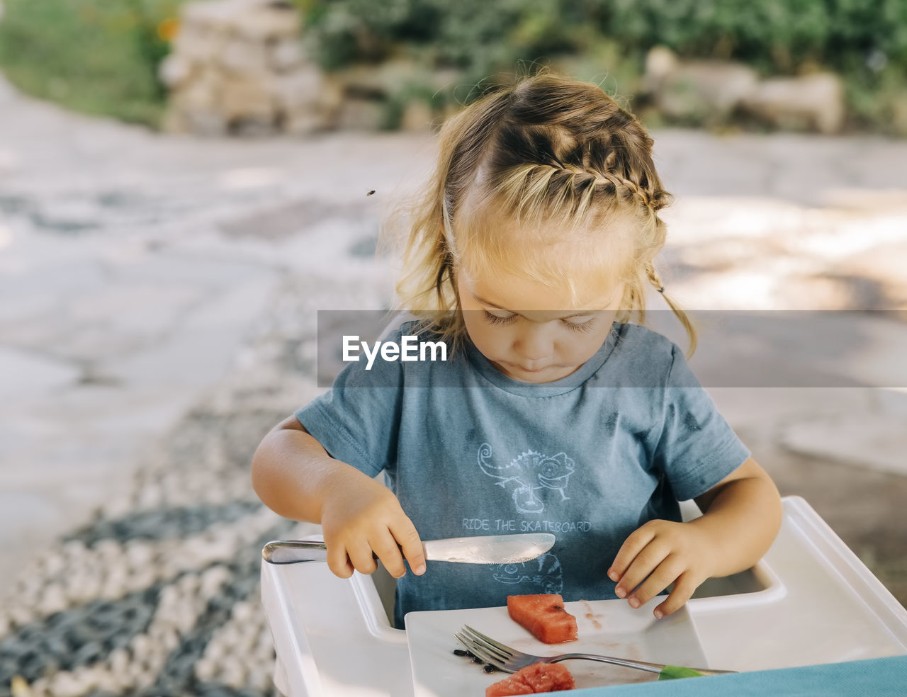 Close-up of girl having food at high chair