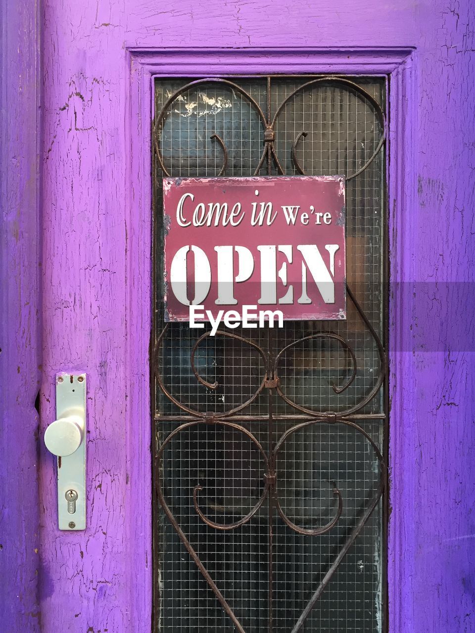 Close-up of open sign on closed door