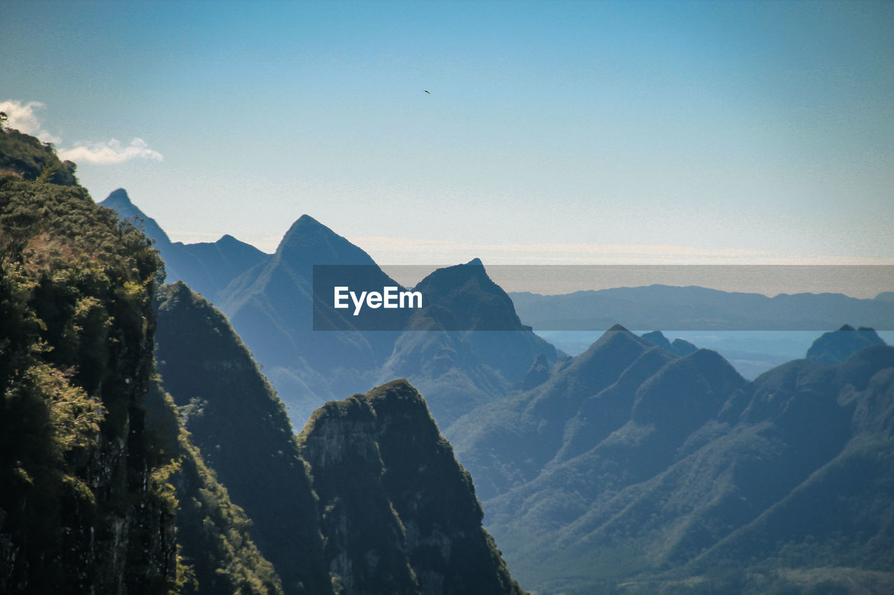 mountain, mountain range, scenics - nature, sky, environment, landscape, nature, beauty in nature, travel, travel destinations, land, mountain peak, tranquility, no people, blue, panoramic, tranquil scene, outdoors, wilderness, rock, tourism, clear sky, summit, valley, non-urban scene, high up, cloud, sunlight, ridge, activity, forest, idyllic, sunset