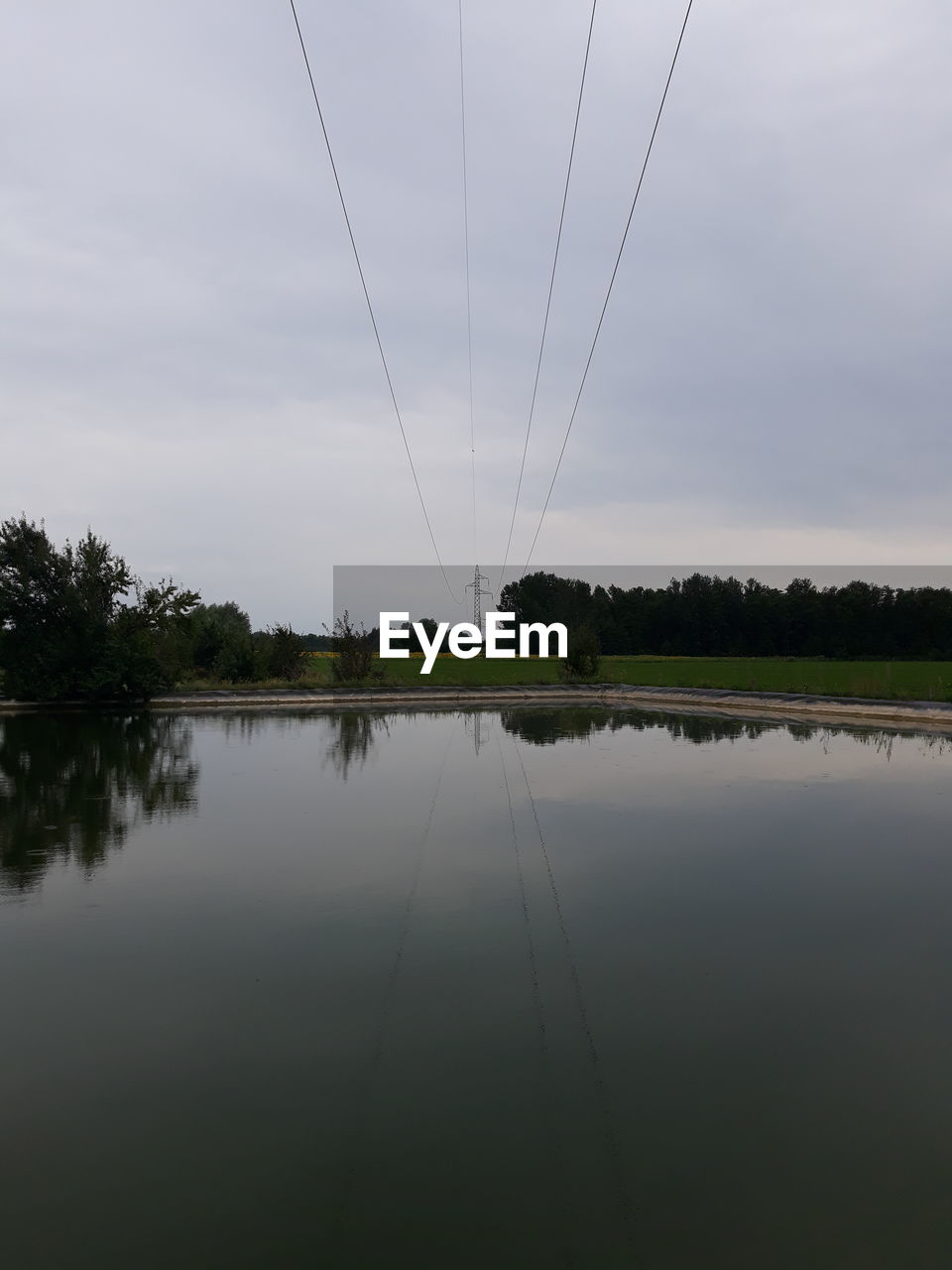 REFLECTION OF TREES ON LAKE AGAINST SKY