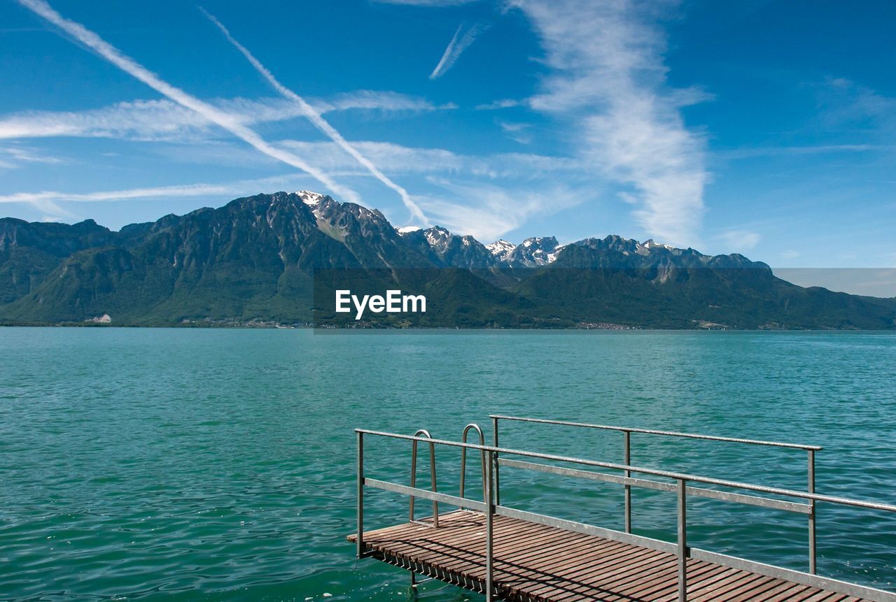 Scenic view of sea by mountains against sky