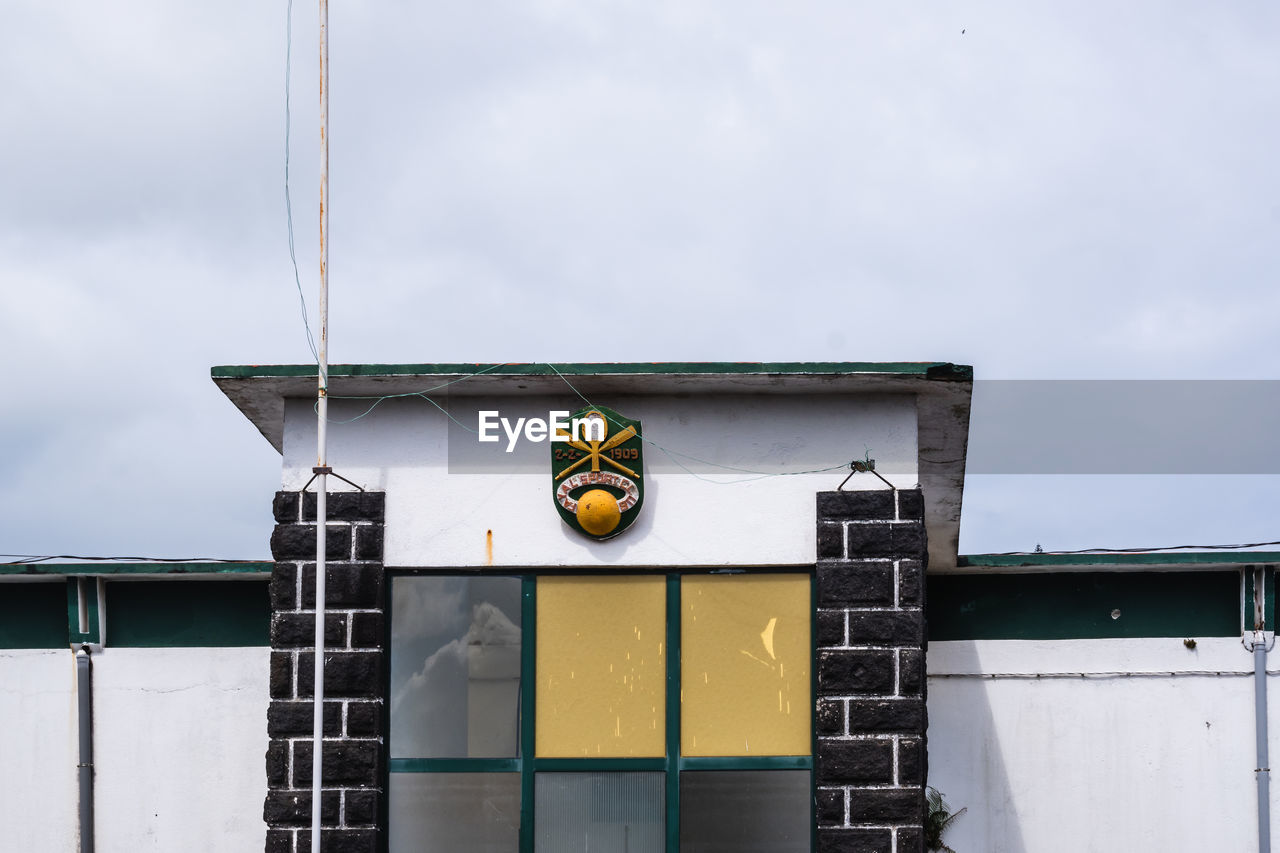 LOW ANGLE VIEW OF YELLOW SIGN ON BUILDING