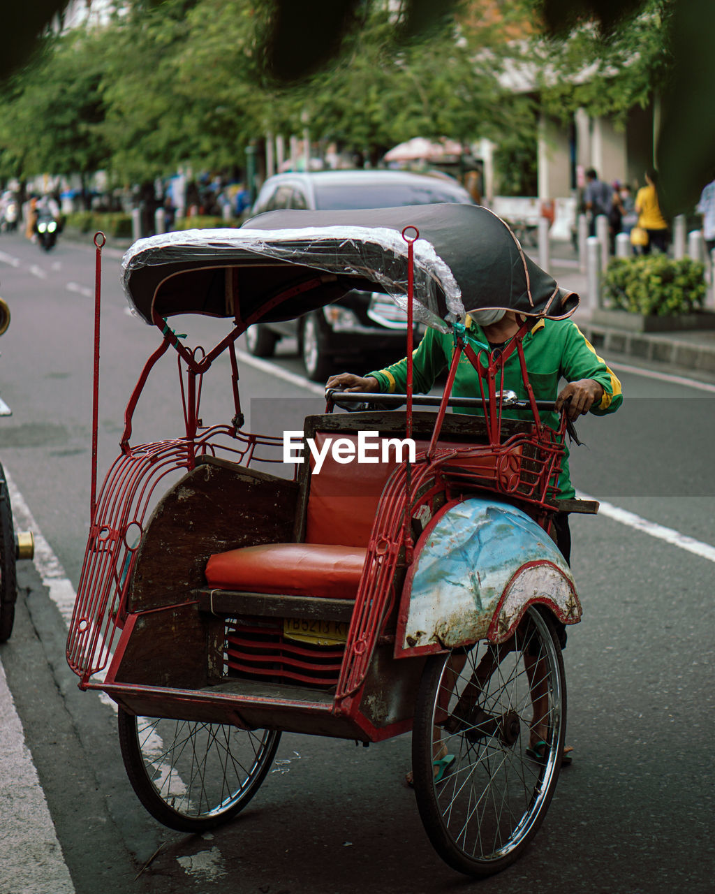 Man pushing rickshaw on road