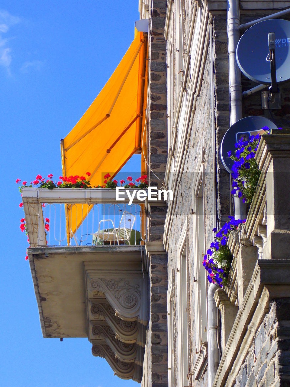 LOW ANGLE VIEW OF MULTI COLORED BUILDING AGAINST BLUE SKY