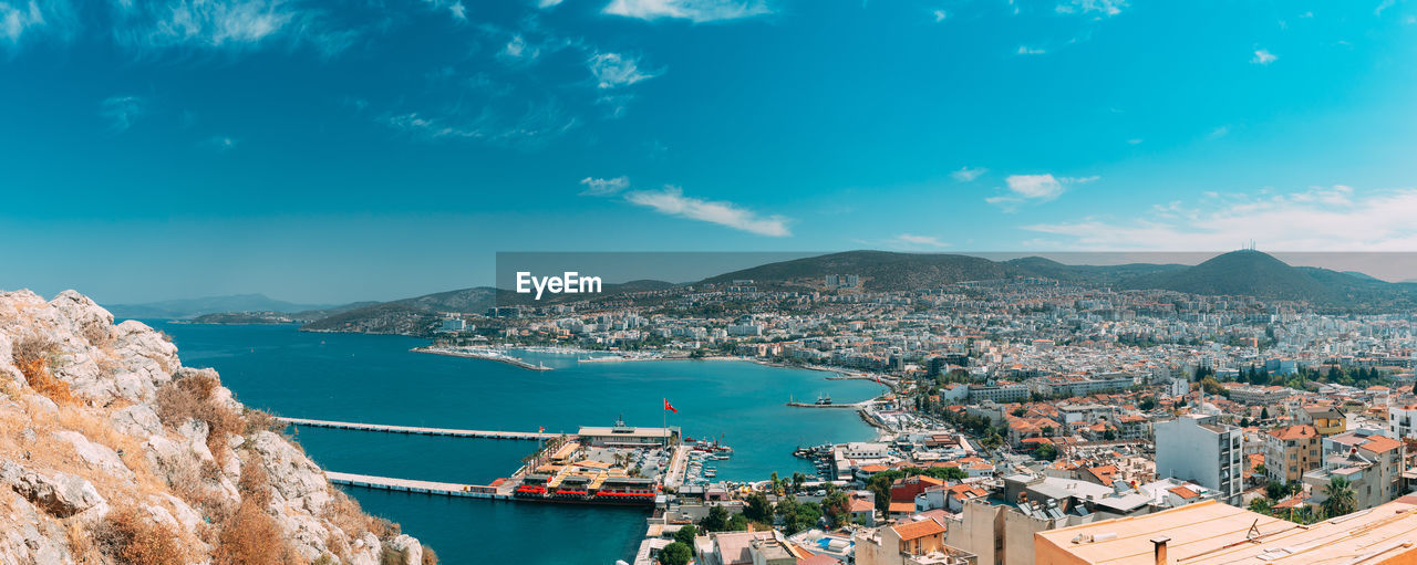 high angle view of buildings by sea against sky