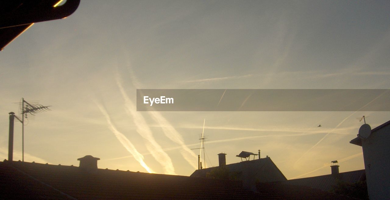 Low angle view of silhouette houses against sky