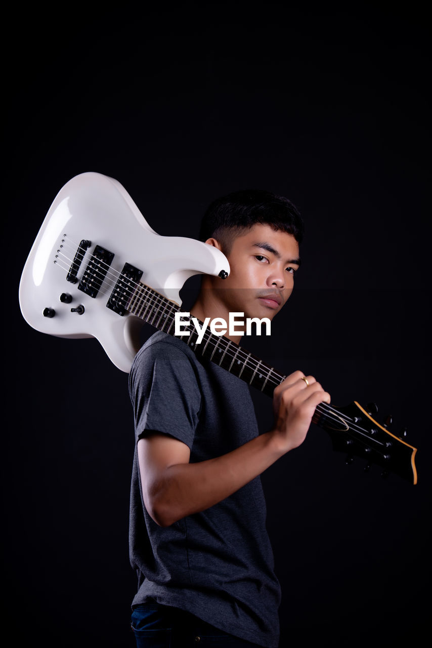 FULL LENGTH PORTRAIT OF A YOUNG MAN WITH ARMS RAISED