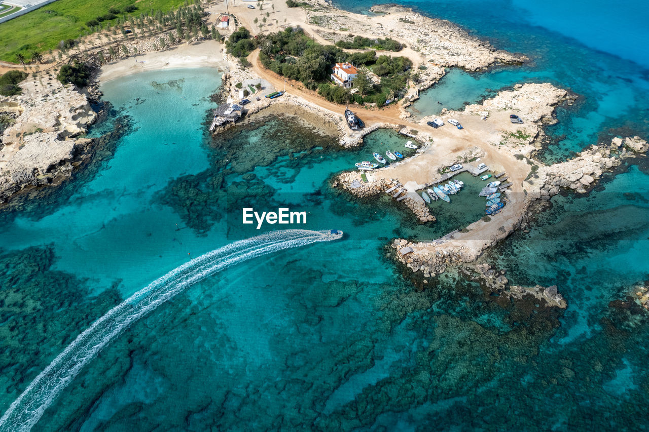 Aerial drone of fishing speed boat entering and moored at the harbor.