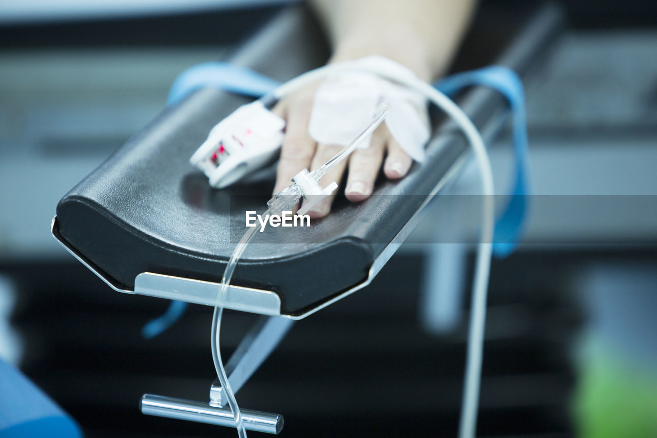 Cropped hand of patient with iv drip at hospital