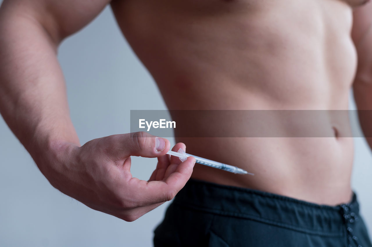 midsection of man holding syringe