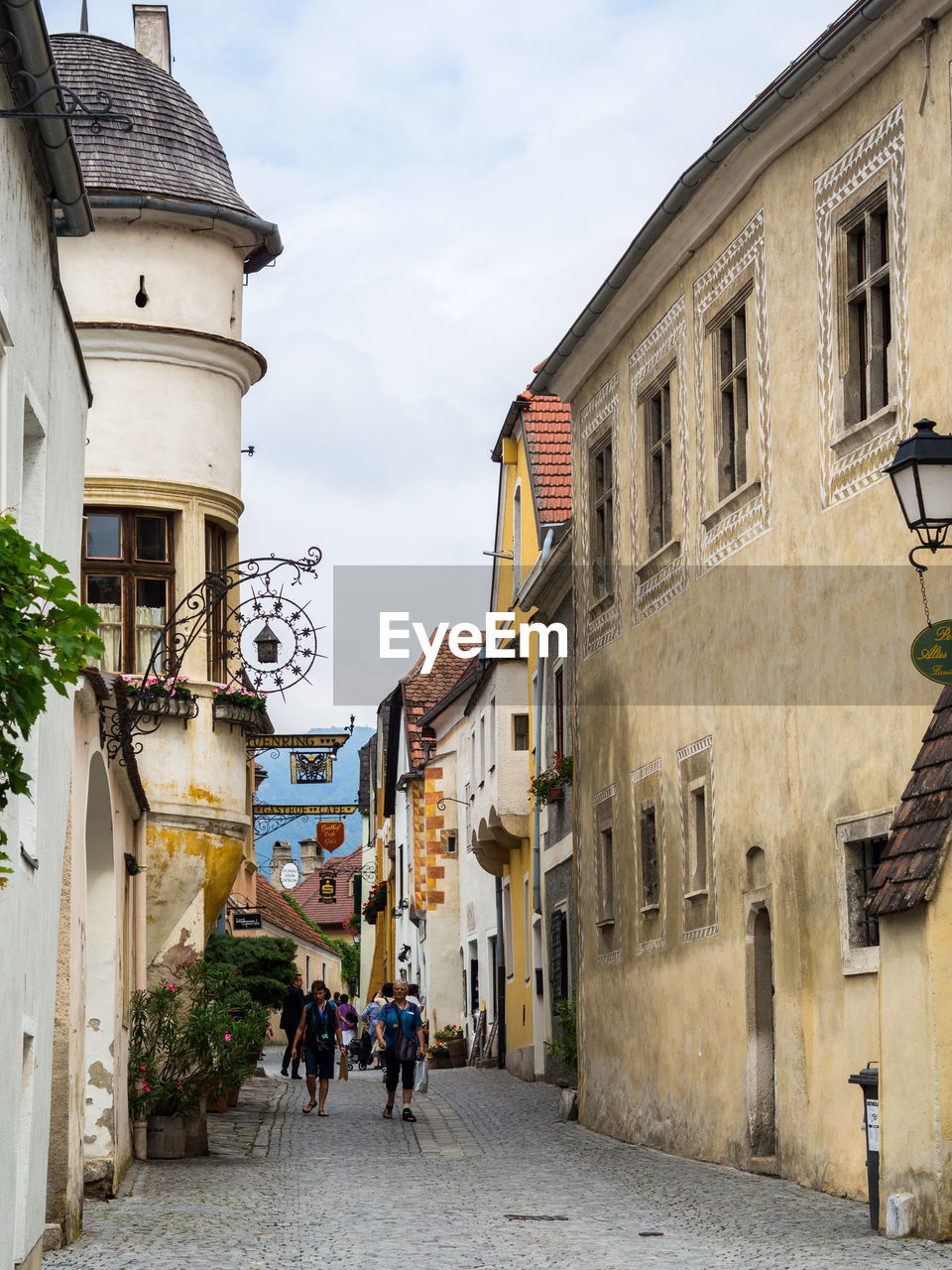 PEOPLE ON STREET AMIDST BUILDINGS IN CITY