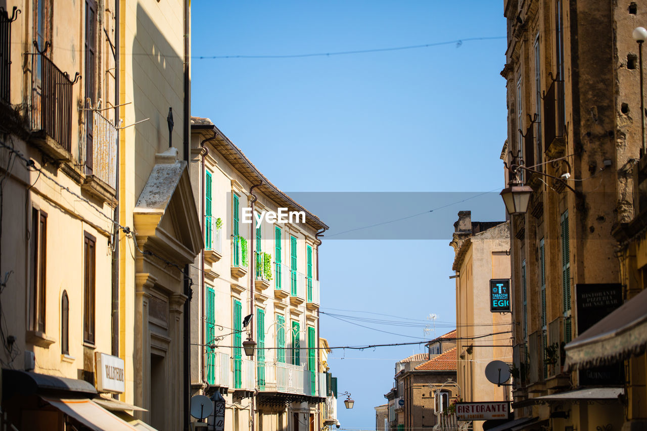 LOW ANGLE VIEW OF BUILDINGS AGAINST BLUE SKY