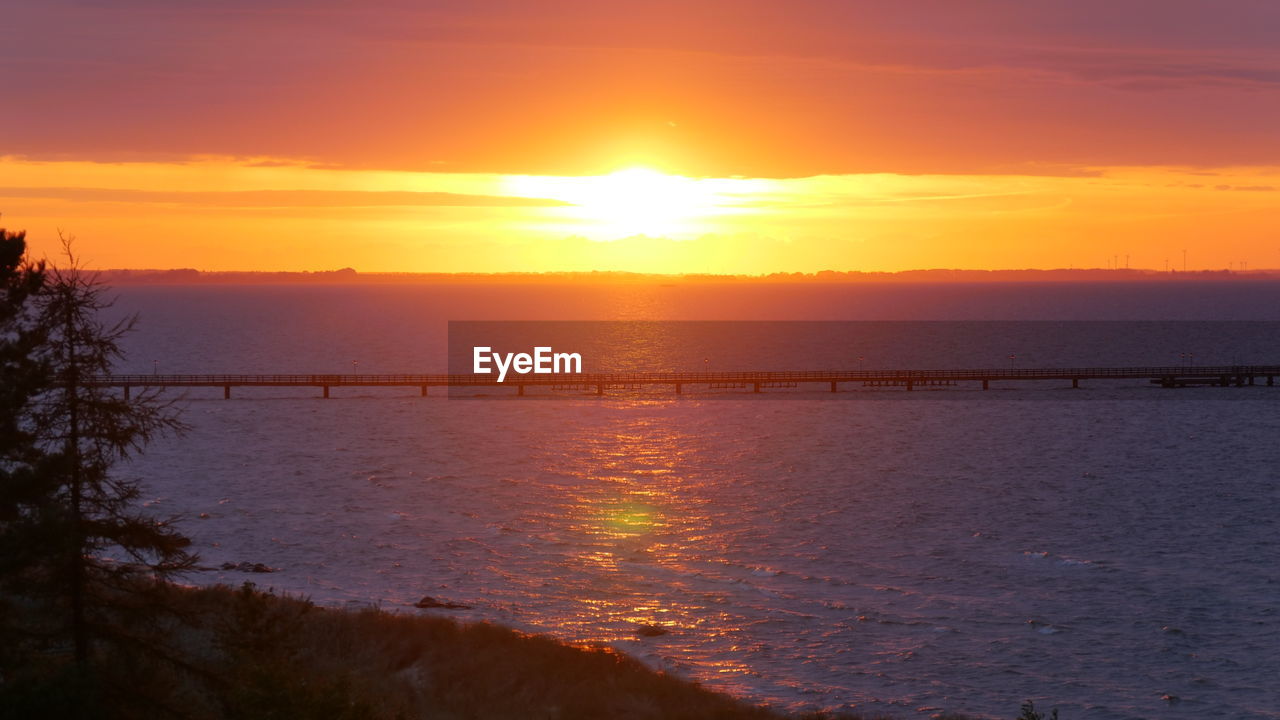 SCENIC VIEW OF SEA AGAINST ORANGE SKY DURING SUNSET