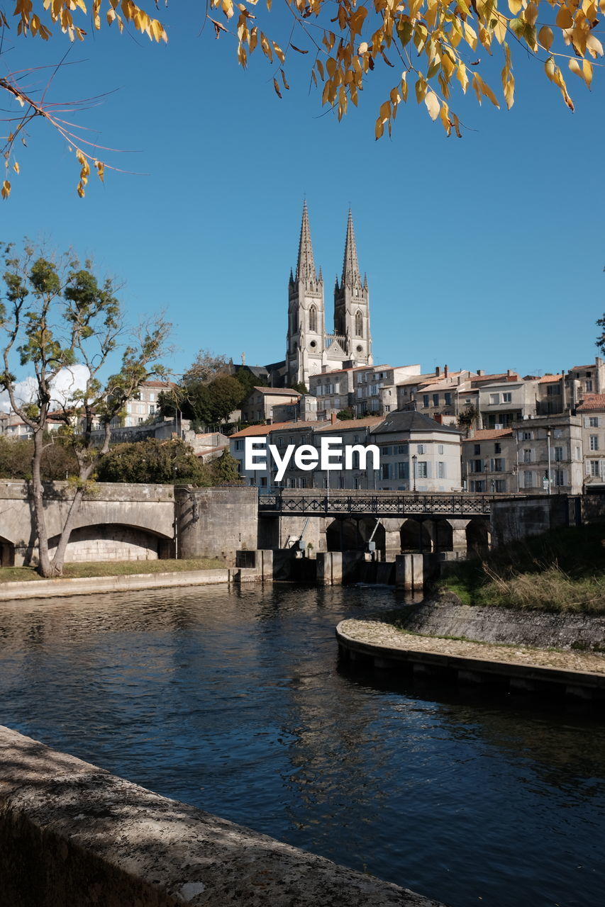 View of building by river against sky