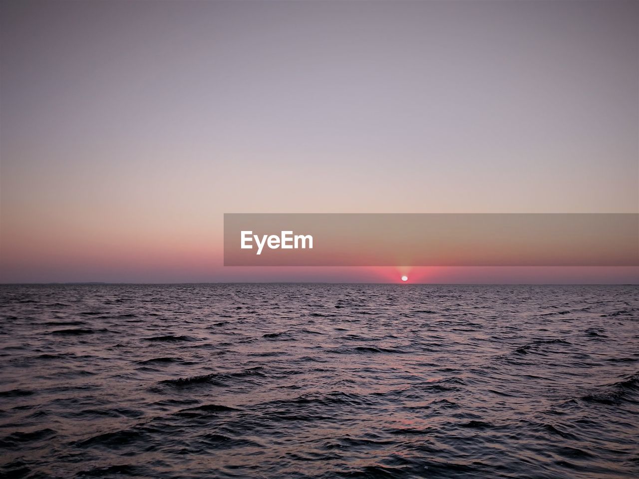 Scenic view of sea against clear sky during sunset