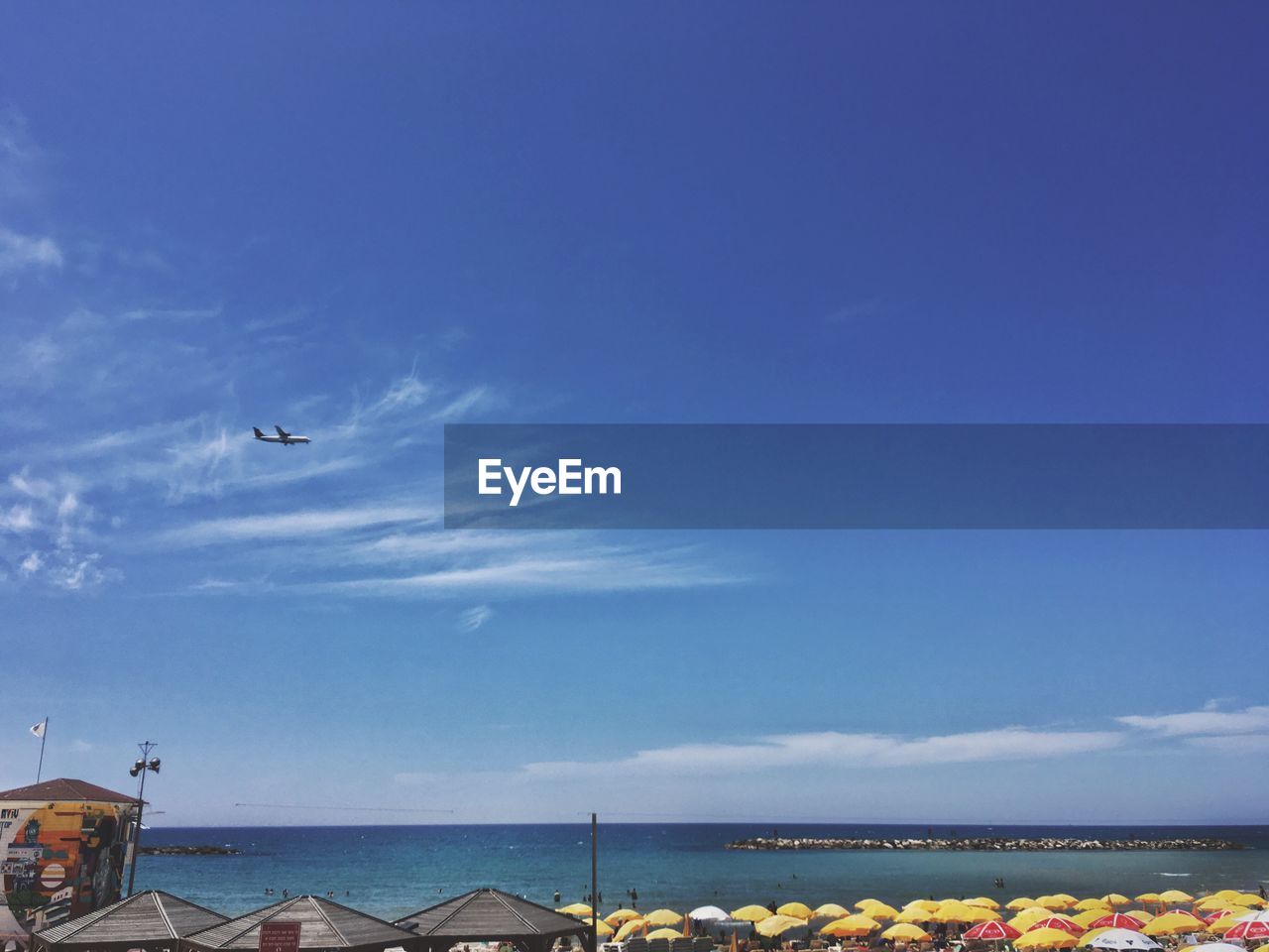 BIRD FLYING OVER SEA AGAINST SKY