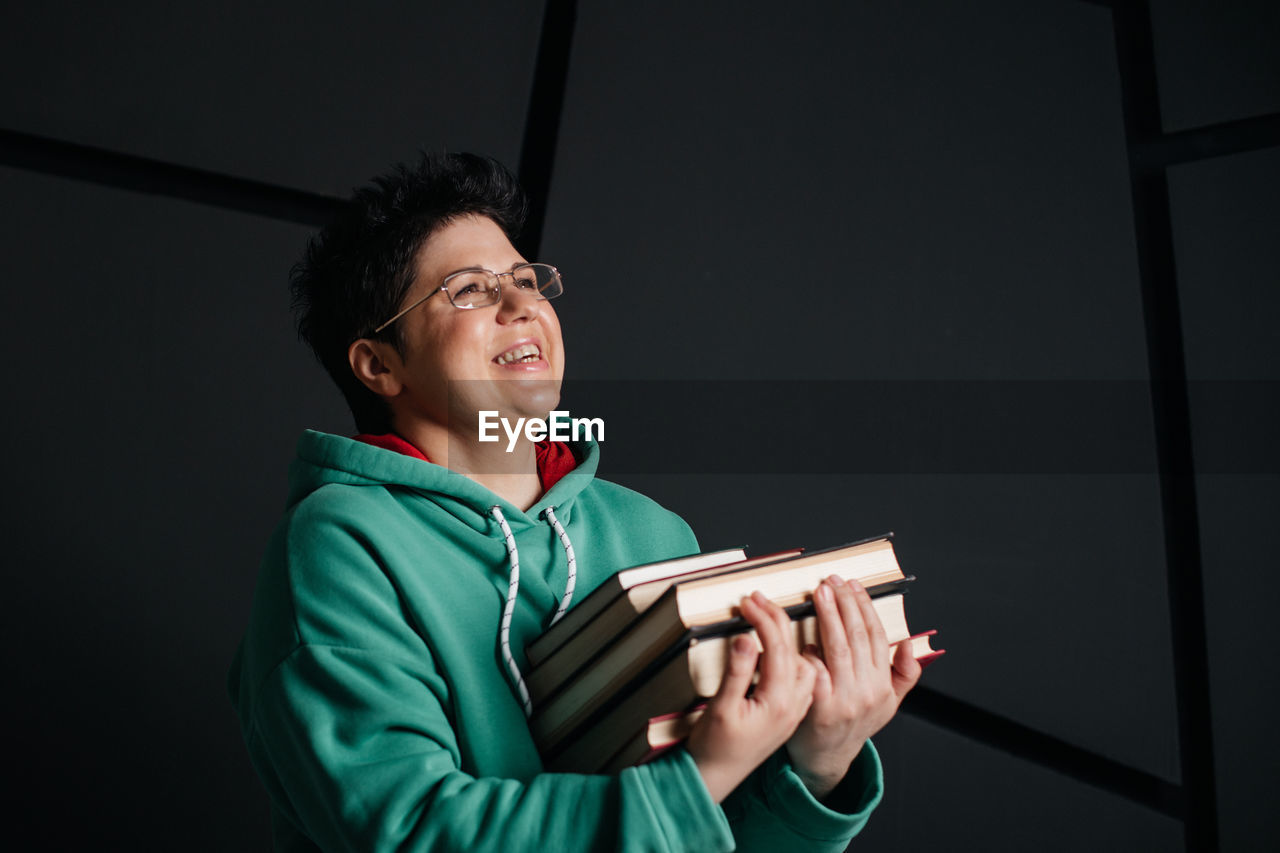 YOUNG MAN LOOKING AWAY WHILE BOOK