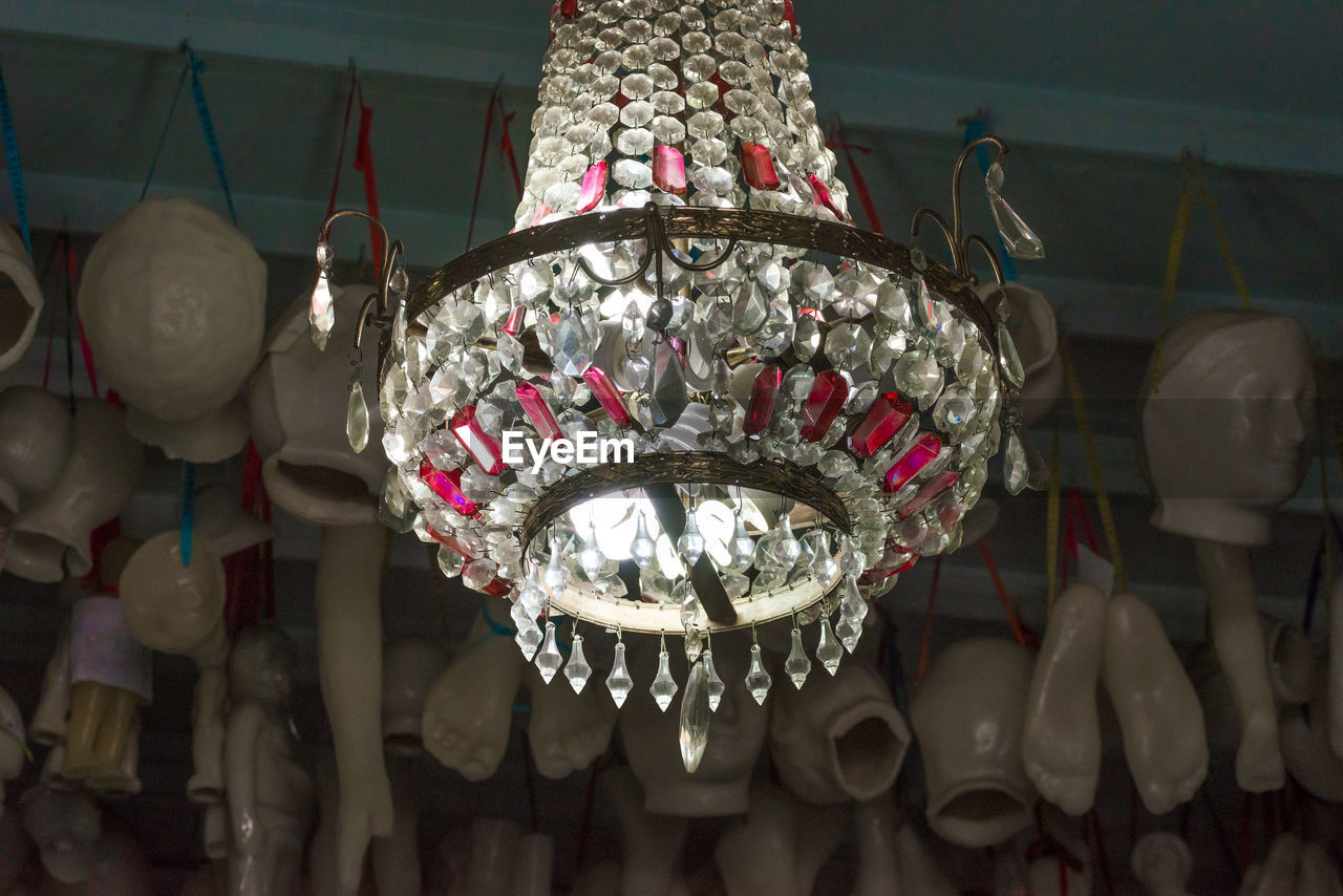 LOW ANGLE VIEW OF ILLUMINATED DECORATION HANGING FROM CEILING