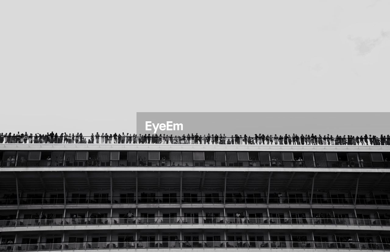 People standing on building terrace against sky