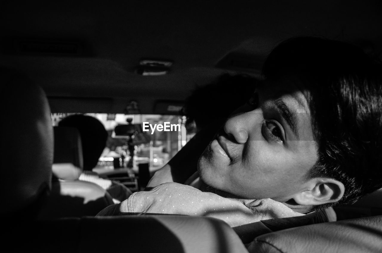 Portrait of young man sitting in car