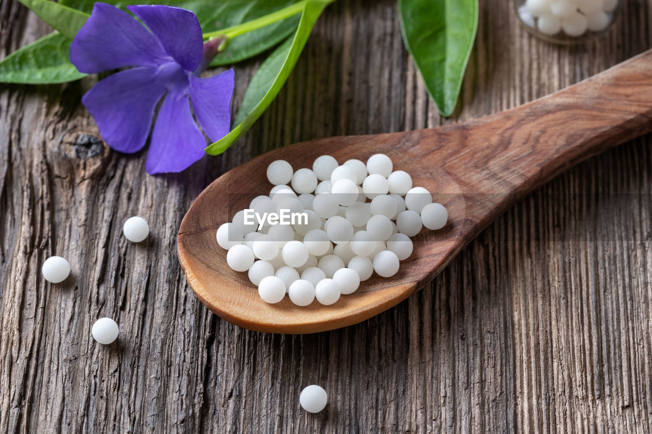 HIGH ANGLE VIEW OF WHITE FLOWERS ON WOODEN TABLE