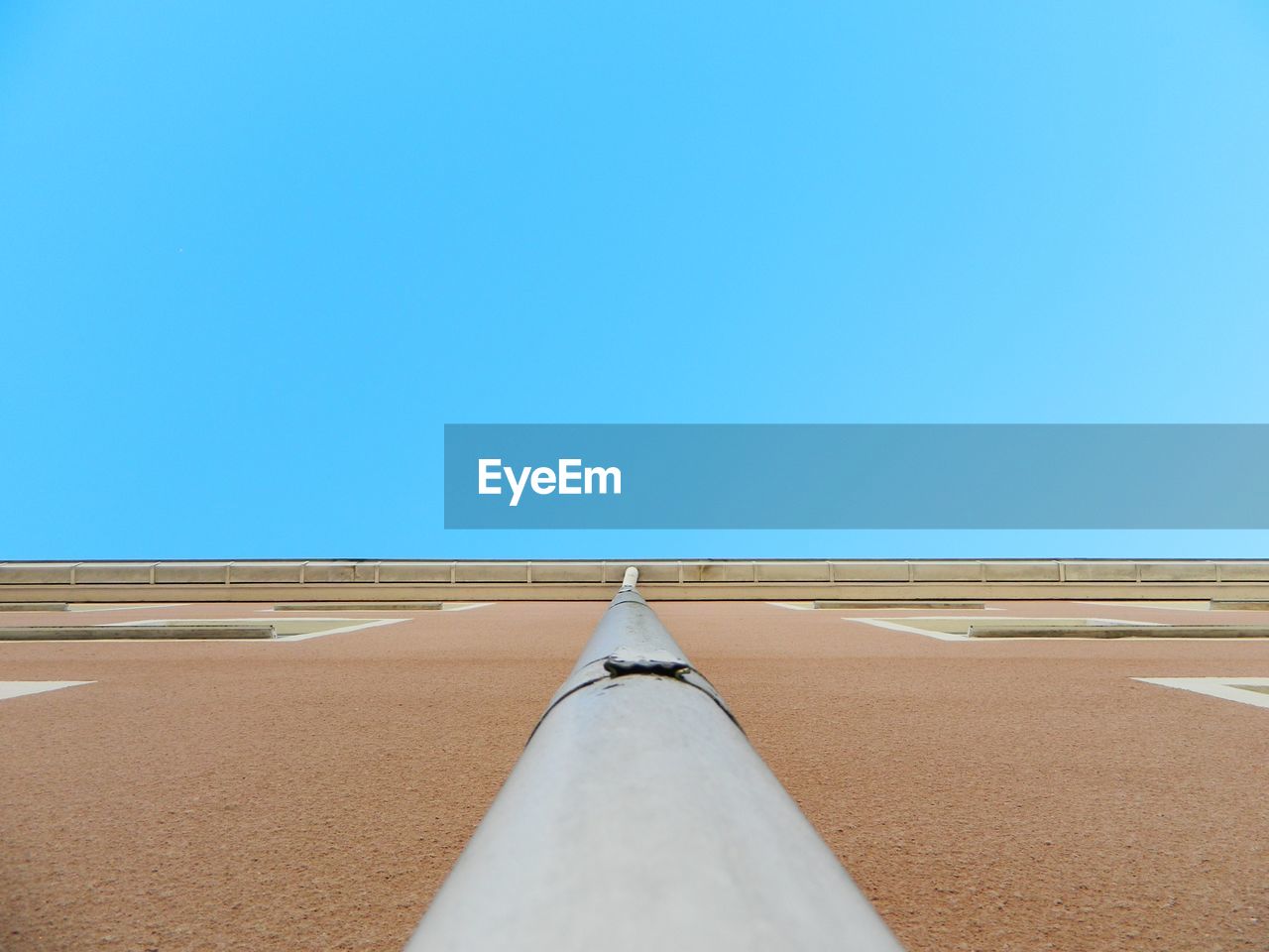 Tilt image of sand against clear blue sky