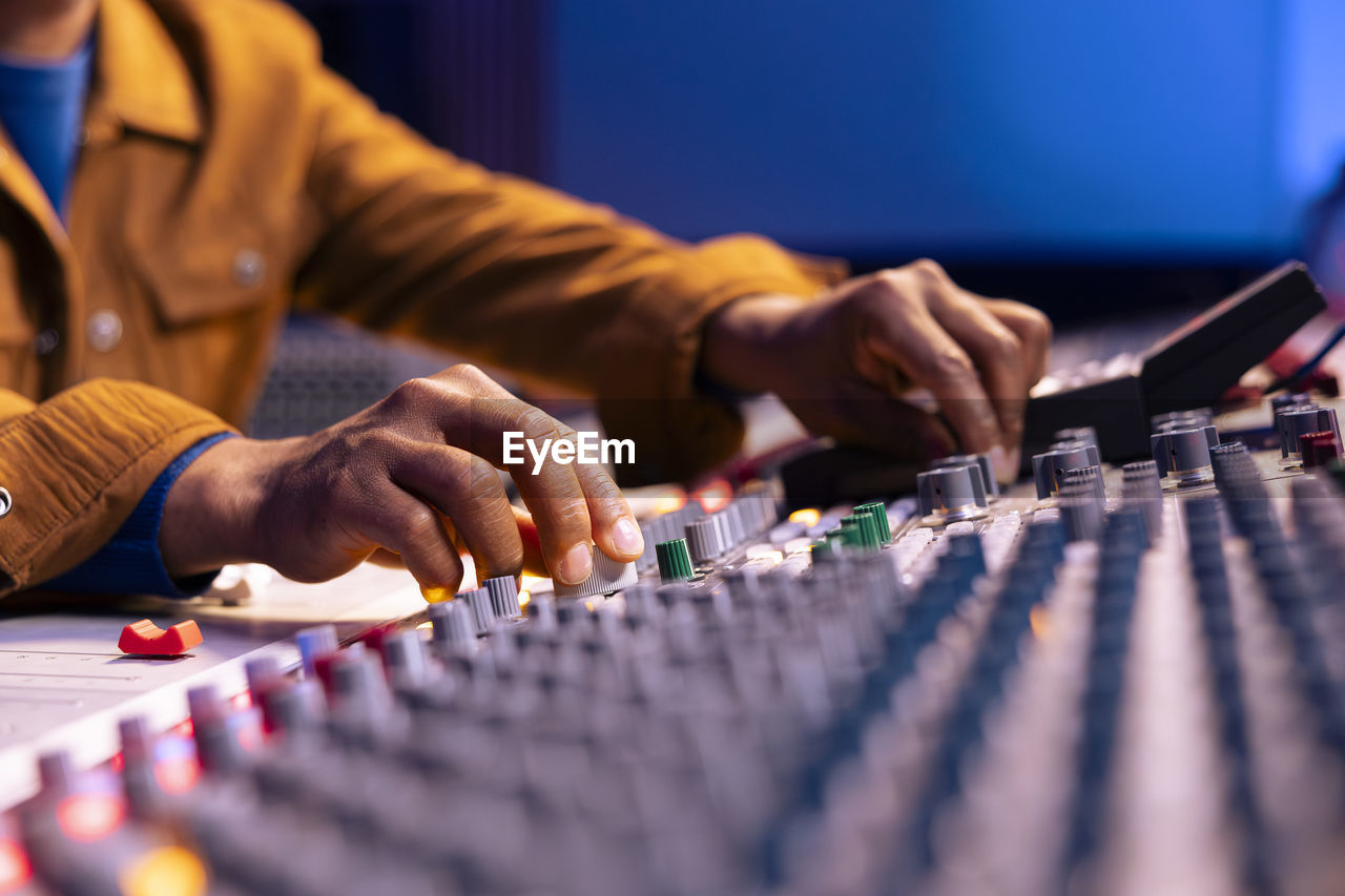 midsection of man using sound mixer