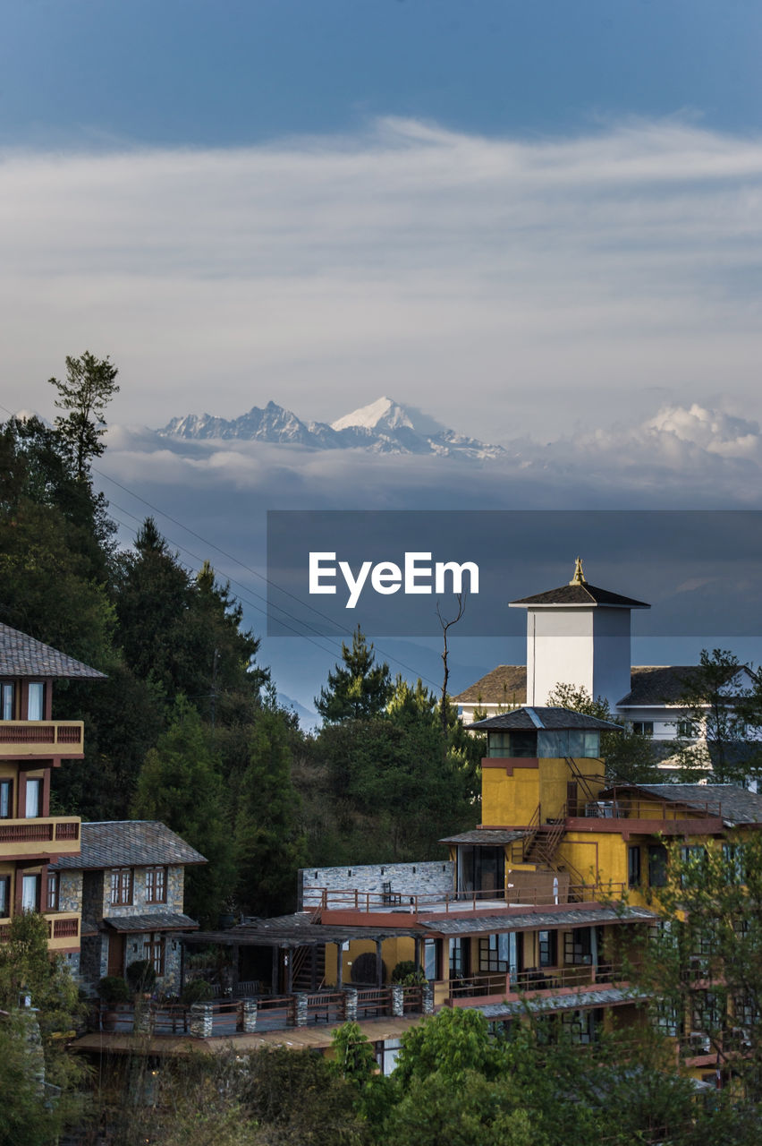 Houses by mountains against sky