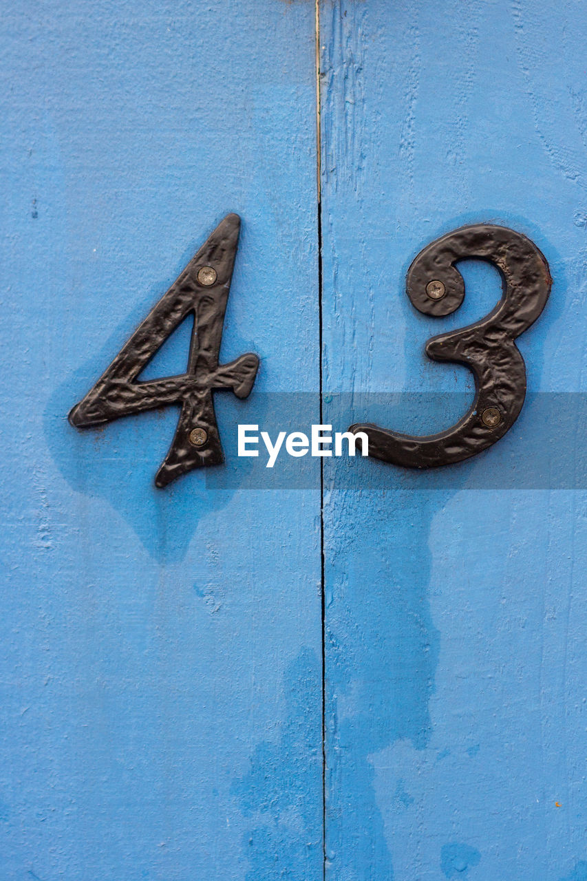 House number 43 on a blue wooden front door in london 