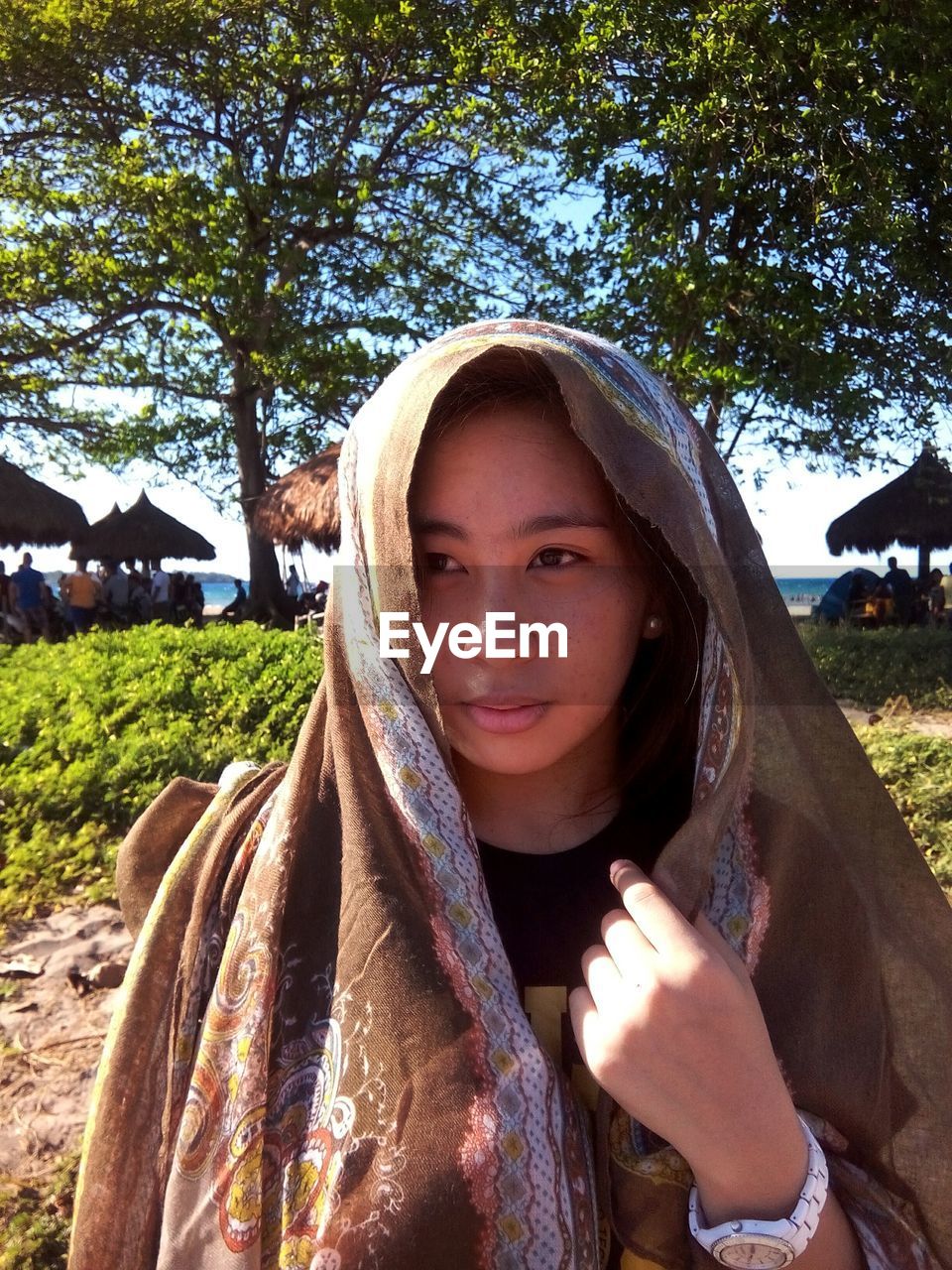 PORTRAIT OF YOUNG WOMAN STANDING ON TREE TRUNK