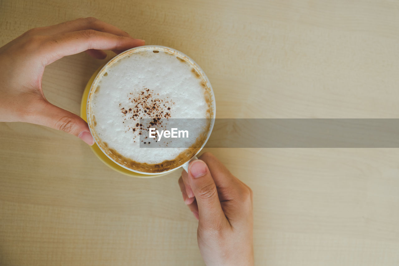 CROPPED IMAGE OF HAND HOLDING COFFEE CUP