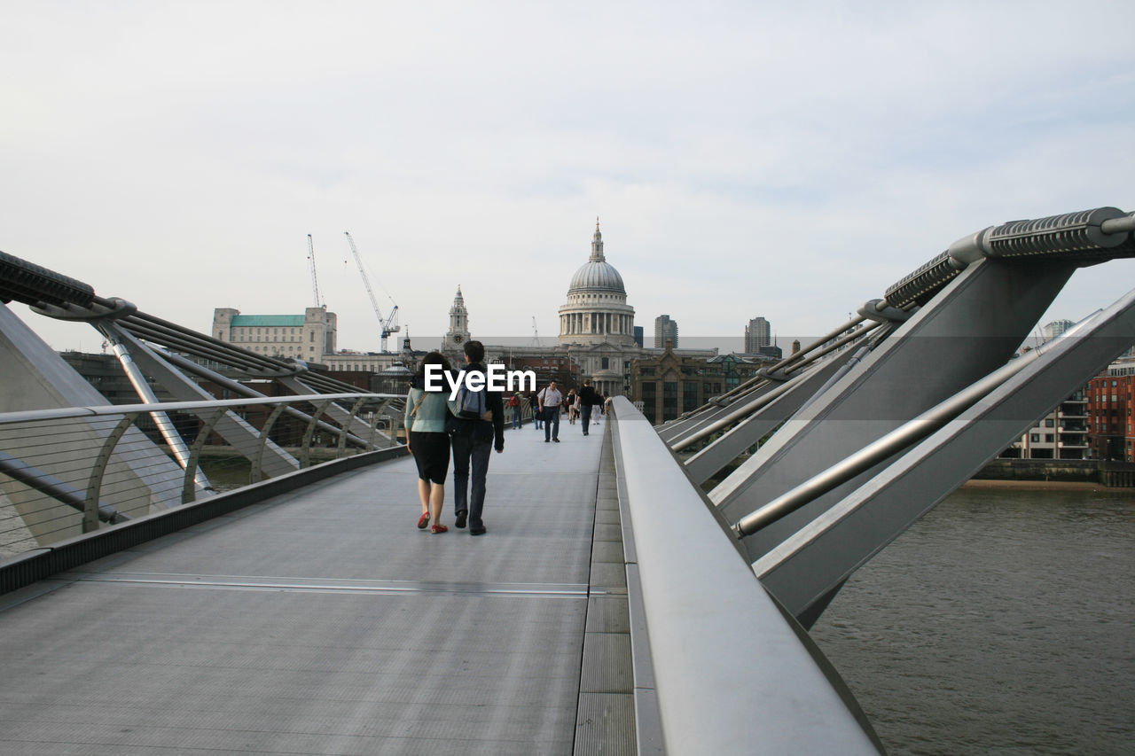 People on london millennium footbridge leading towards st paul cathedral