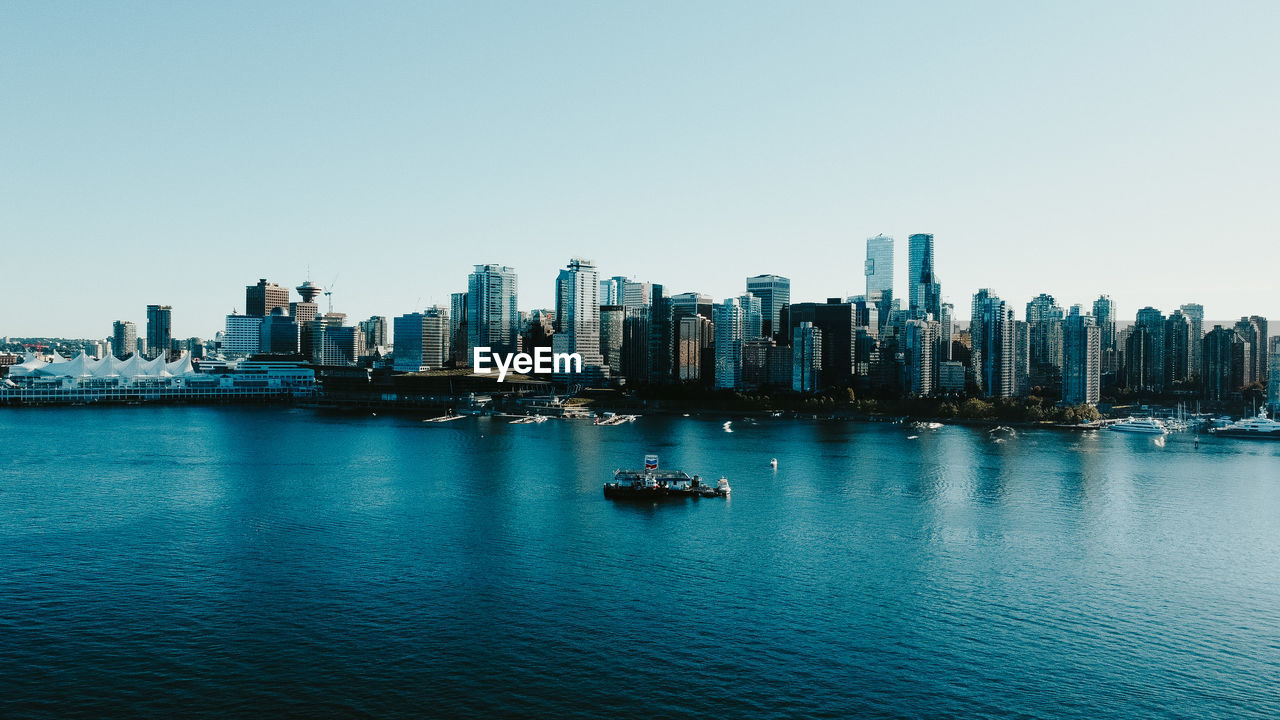 SCENIC VIEW OF SEA AGAINST BUILDINGS IN CITY