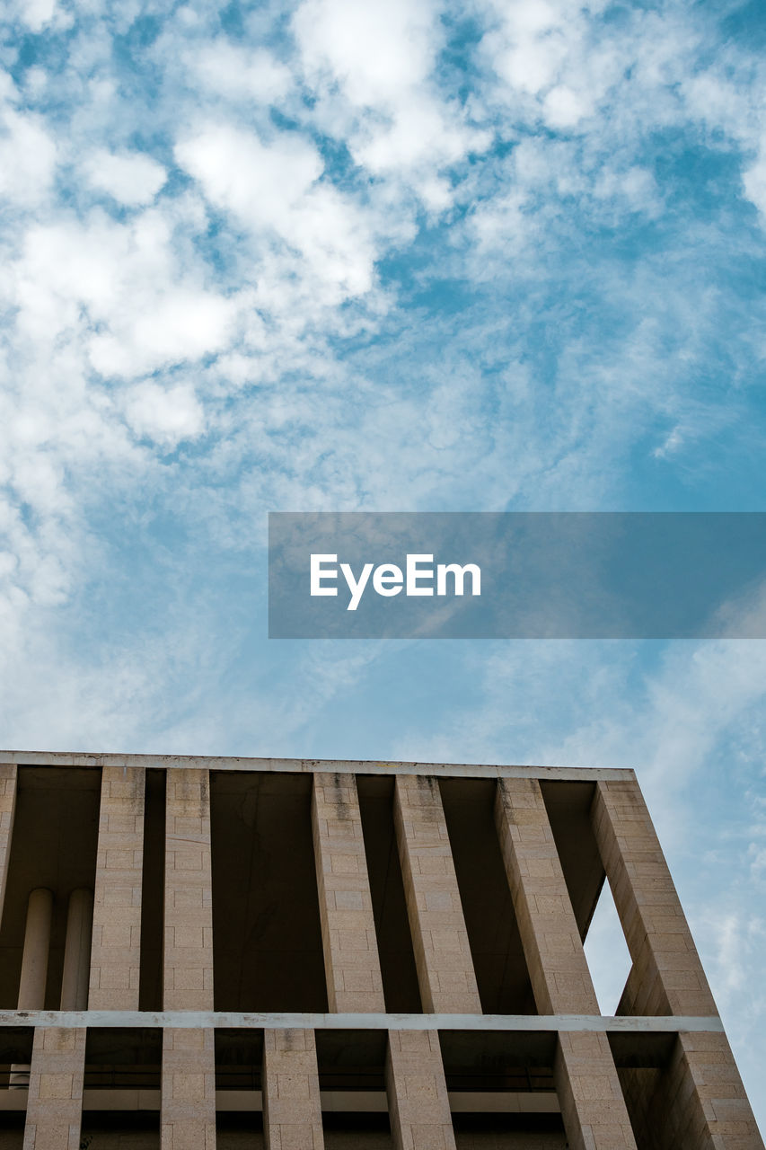 Low angle view of building against cloudy sky