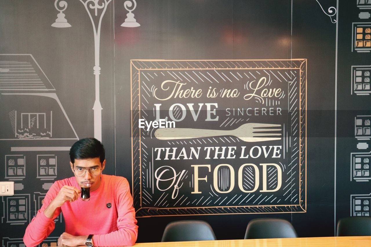 FULL LENGTH PORTRAIT OF YOUNG MAN WITH TEXT IN BACKGROUND