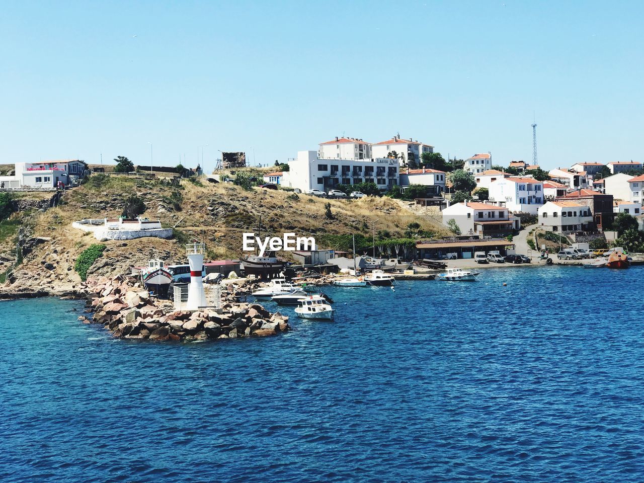 SAILBOATS IN SEA AGAINST BUILDINGS IN CITY AGAINST CLEAR SKY