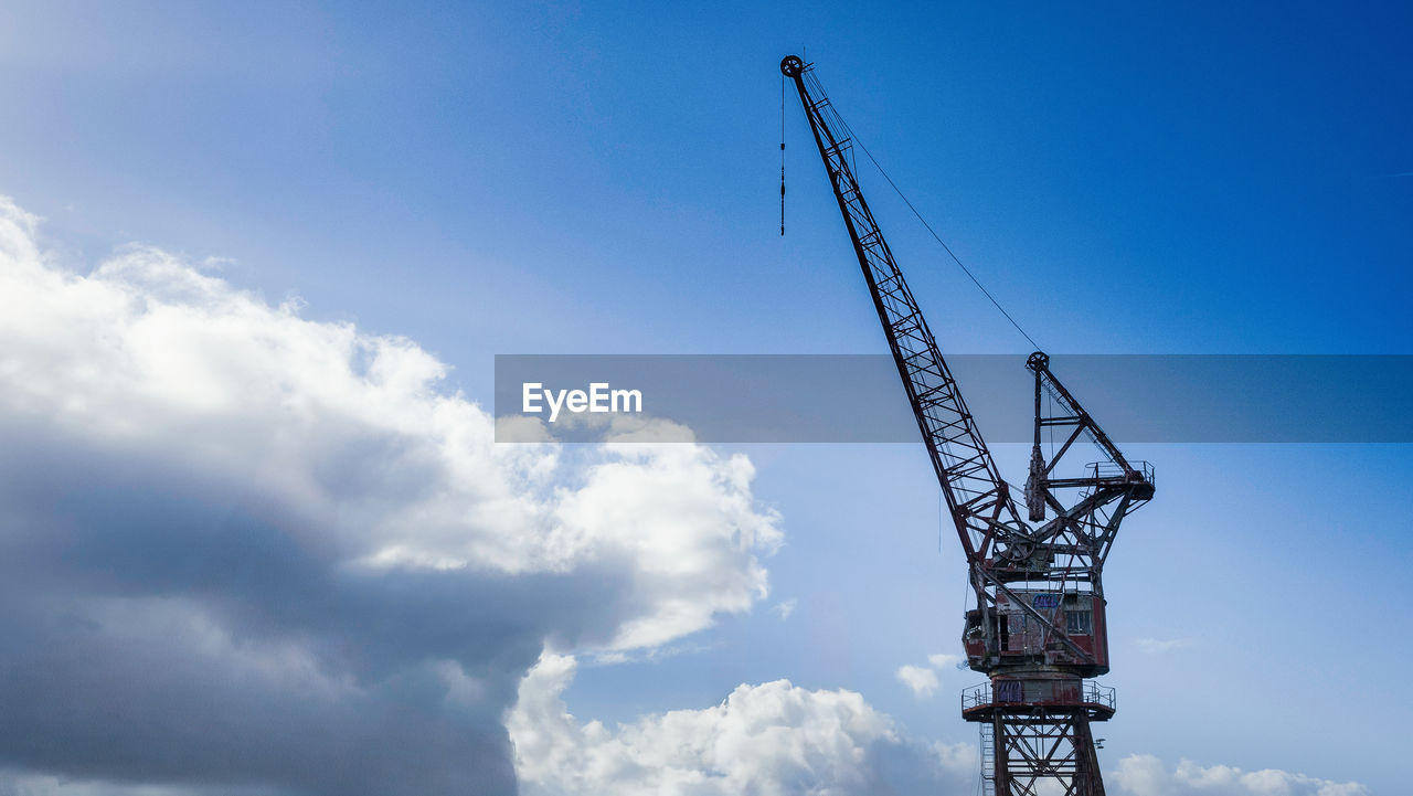 sky, crane - construction machinery, machinery, cloud, industry, construction industry, architecture, construction site, nature, blue, development, construction machinery, business, no people, business finance and industry, built structure, metal, vehicle, equipment, outdoors, tower, low angle view, day, technology, electricity, mast, copy space, transportation