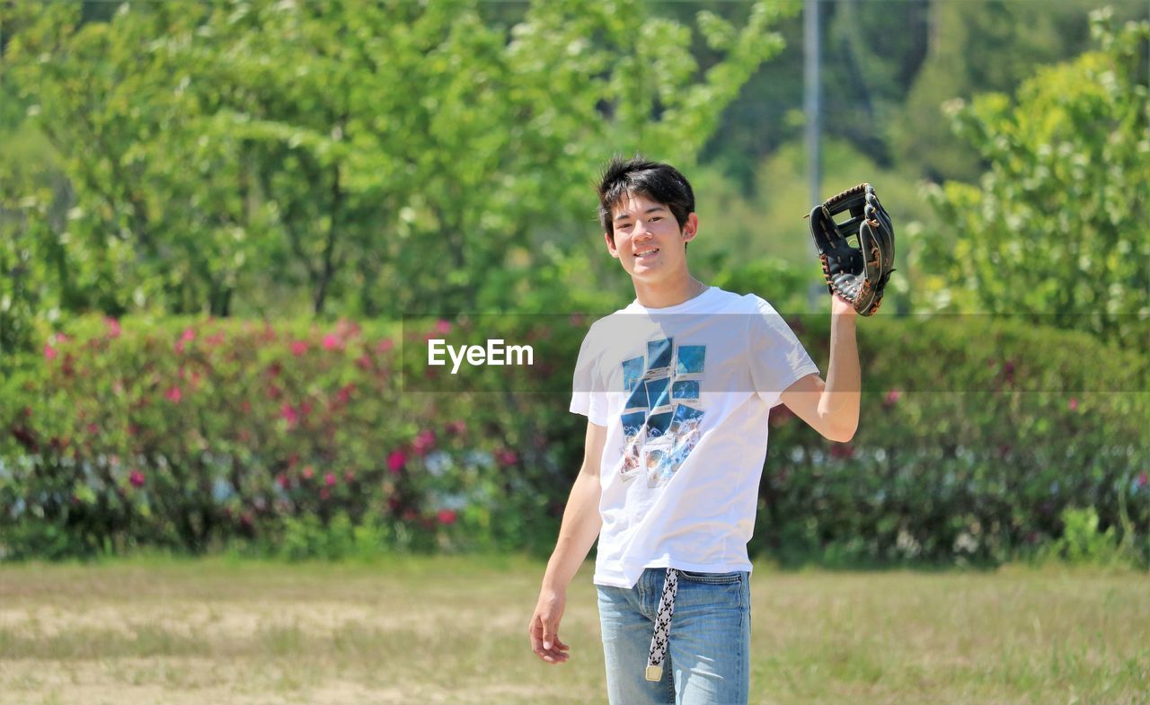 PORTRAIT OF SMILING MAN HOLDING CAMERA